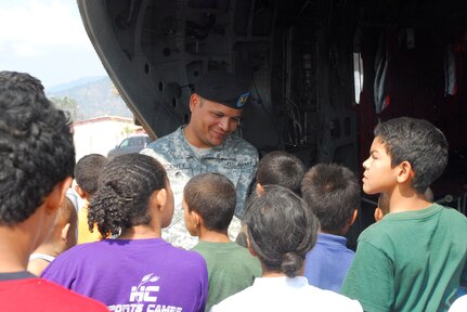 LA PAZ, Honduras - U.S. Army Sgt. Joselito Vicenty talks to local children as they look at a CH-47 Chinook helicopter here April 22. Sergeant Vicenty and 10 other U.S. servicemembers were in La Paz, participating in Fuerzas Aliadas Humanitarias, or FA-HUM '09 -- a multinational exercise designed to test emergency response capabilities during multiple simulated disaster situations. (U.S. Air Force photo/Tech. Sgt. Mike Hammond)