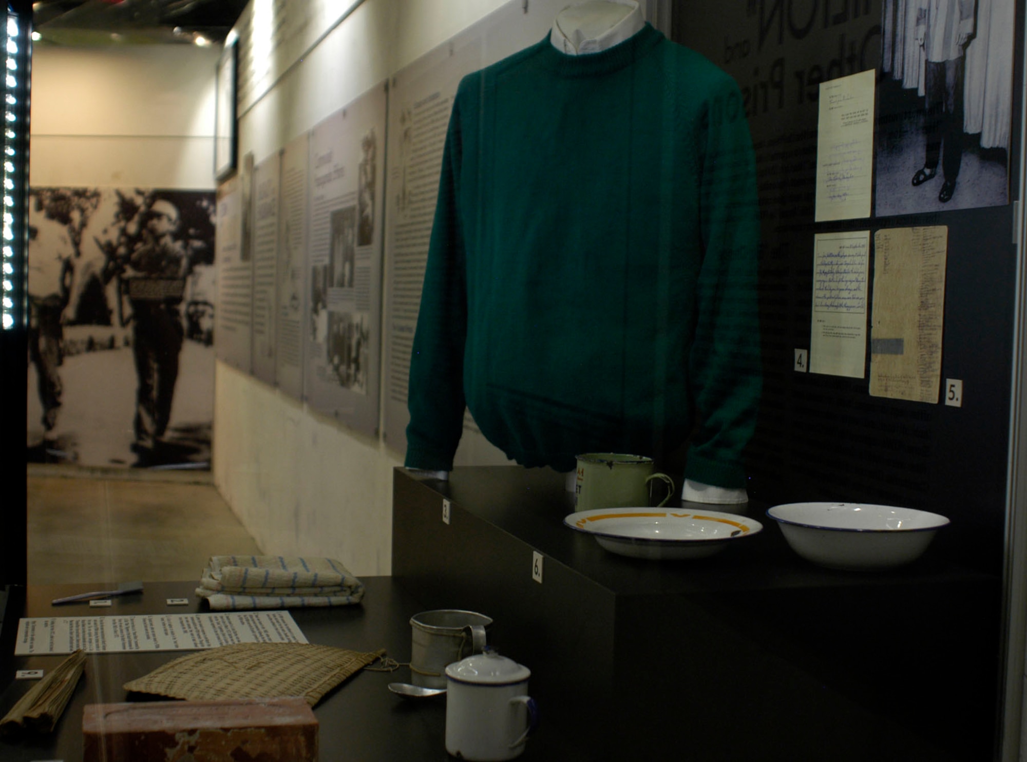 DAYTON, Ohio - Typical bowls, plate and spoons issued to POWs. Knives and forks were not provided. Also shown is a toothbrush a POW received from a package from home, a towel that was issued to POWs, a sweater issued to Lt. Jack Butcher, a brick from the "Hanoi Hilton," a fan used during the hottest months and a folding fan. (U.S. Air Force photo)