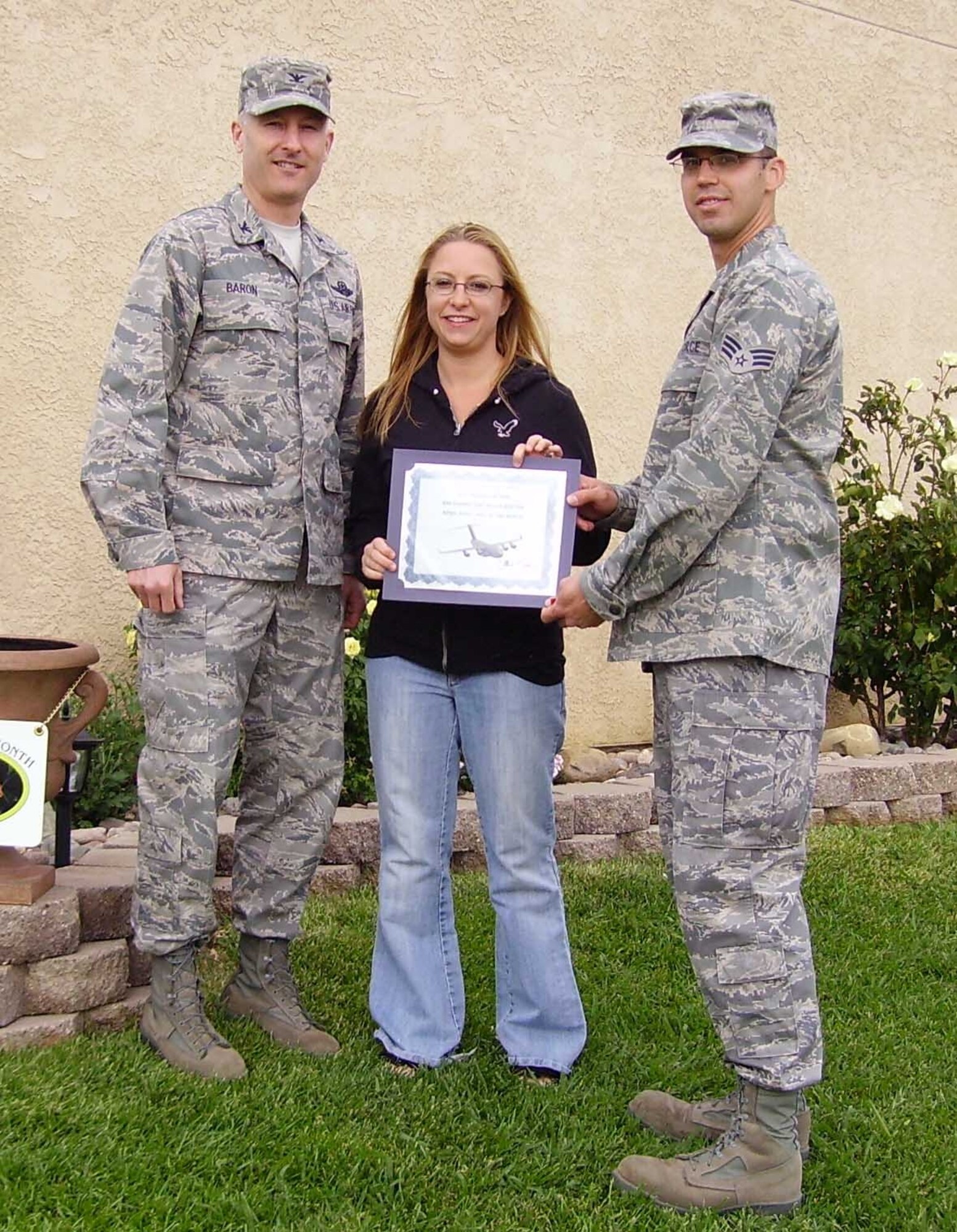 Col. Jim Baron, 60th Air Mobility Wing acting vice commander, (left), stands with Senior Airman Michael McBee, 60th Aerial Port Squadron, and his wife Joleen. The couple received the Yard of the Month award for outstanding pride and beautification of their yard. (U.S. Air Force photo/Master Sgt. Cal Baumann)

