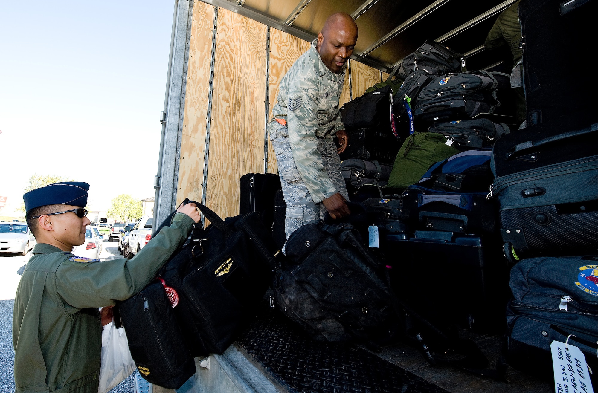 (Right) Tech. Sgt. Raymond Brown, 436th Logistics Readiness Squadron, helps 1st Lt. Jay Weaver, 3rd Airlift Squadron pilot, loads his bags in preparation for the squadron deployment April 26.  This is the first squadron-wide deployment for the 3rd AS. (U.S. Air Force photo\Roland Balik)