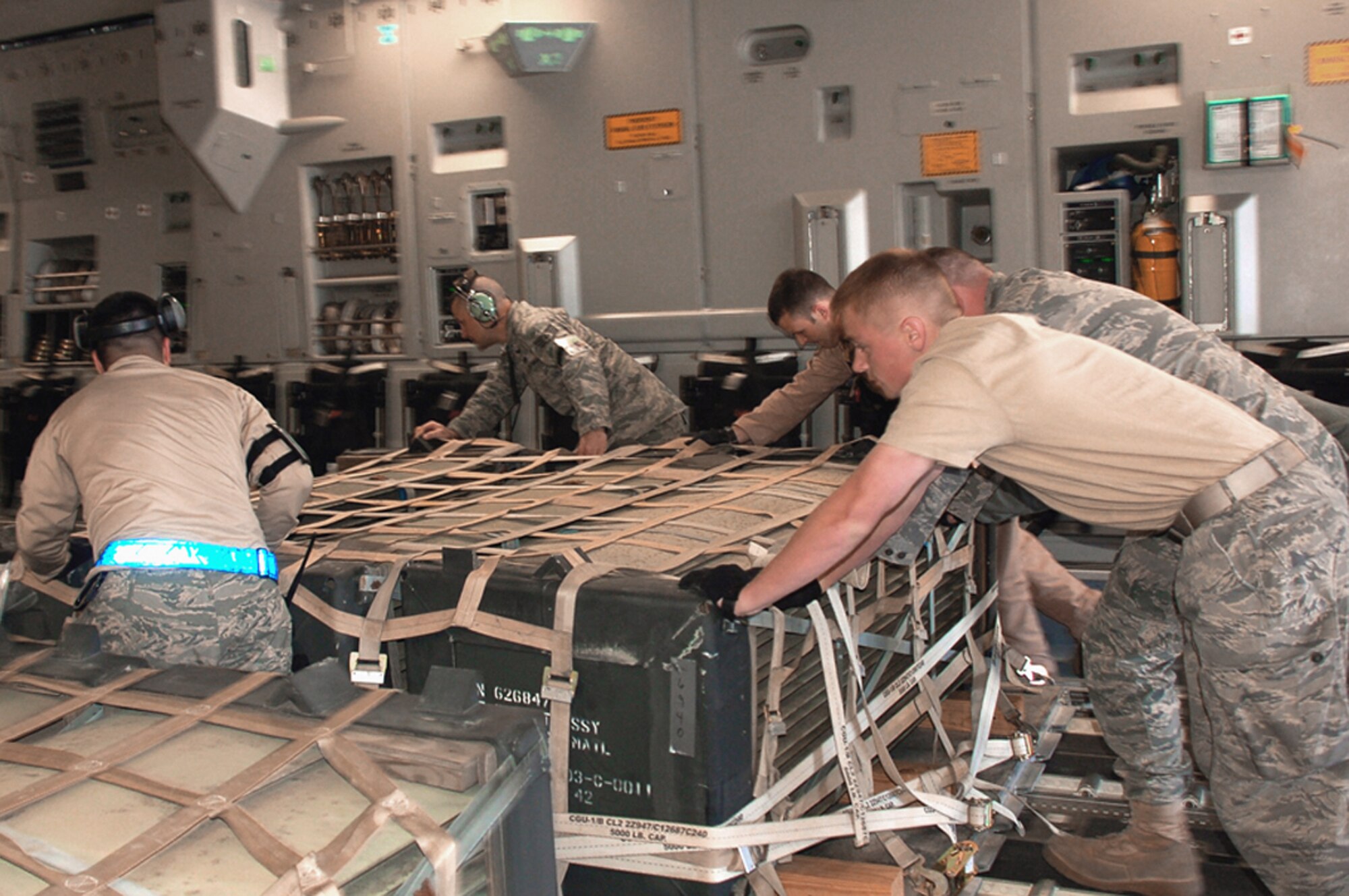 Air crew members and aerial port Airmen work together April 18 to push a pallet of cargo onto a C-17 Globemaster III destined for Afghanistan, from Manas Air Base, Kyrgyzstan. The crews have been flying three flights from Manas nearly every day in order to deliver needed supplies for the buildup of various bases supporting Operation Enduring Freedom. This C-17 is from the 535th Airlift Squadron at Hickam Air Force Base, Hawaii. (U.S. Air Force photo/Tech. Sgt. Phyllis Hanson)