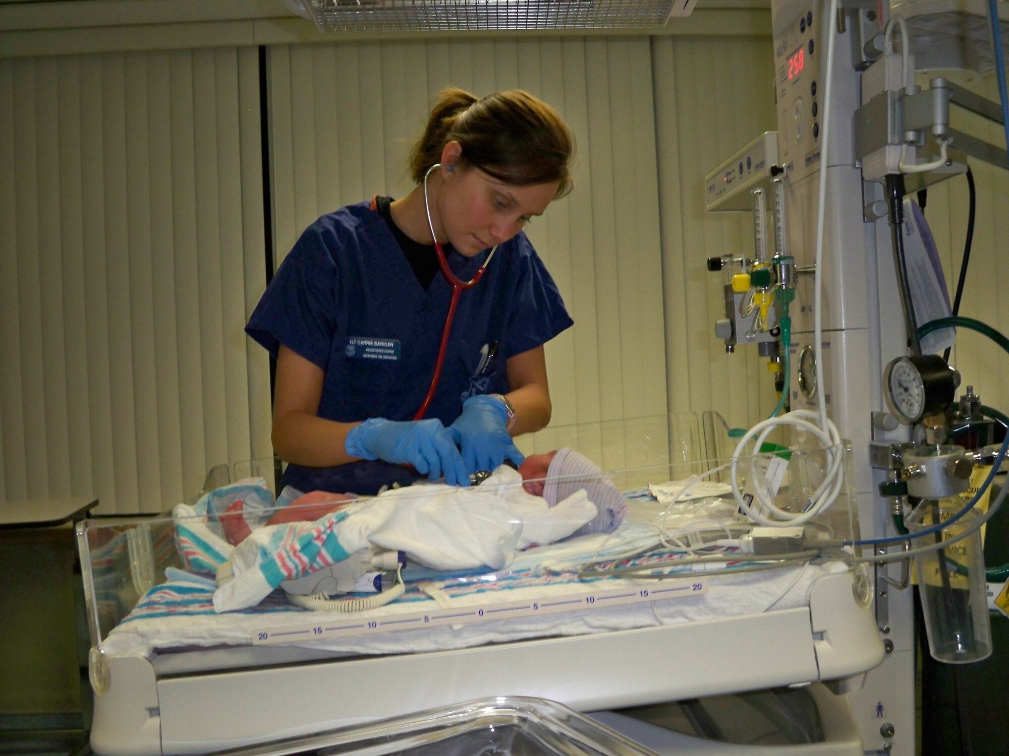 1st Lt. Carrie Banigan, an Inpatient OB Services registered nurse with the 60th Surgical Operations Squadron checks on one of Travis latest arrivals in the Newborn Nursery at David Grant USAF Medical Center. Lieutenant Banigan is one of the hundreds of nurses and medical staff technicians being feted at DGMC during Nurse / Technician Appreciation Week as part of National Nurses Week held annually May 6 through 12. (USAF Photo / 2nd Lt. Jessica Scirica)