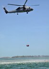 A student gets a lift in the basket while other students and Navy divers watch from below during water survival training.  The training took place during the April UTA at NAS Key West, Fla.