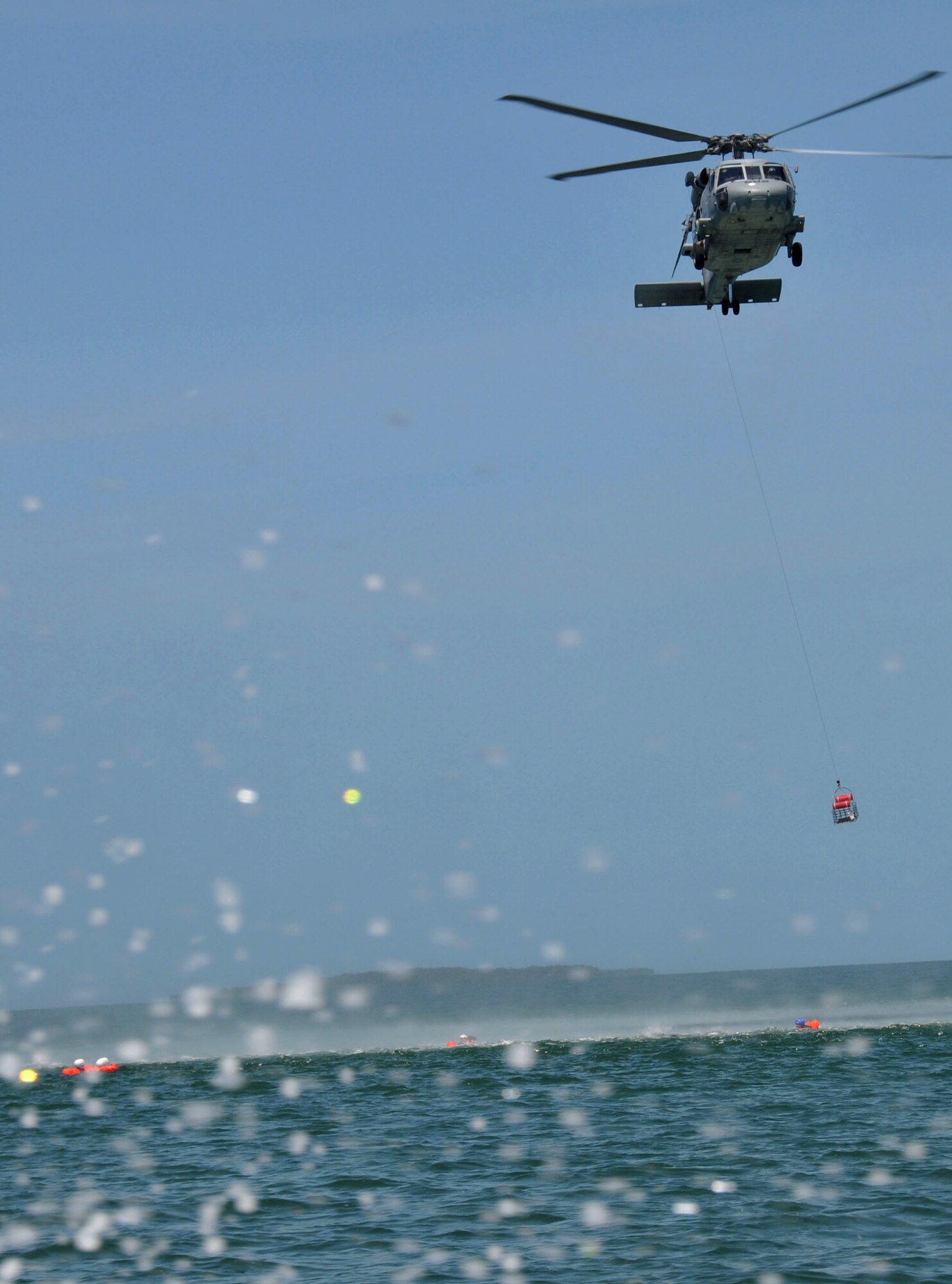 The rescue basket is lowered from a Navy H-60 helicopter during the hoist operations phase of water survival at NAS Key West, Fla.  Water survival training is required for all air crew and aero medical personnel every two years. (Air Force Photo/Master Sgt. Kerry Bartlett)
