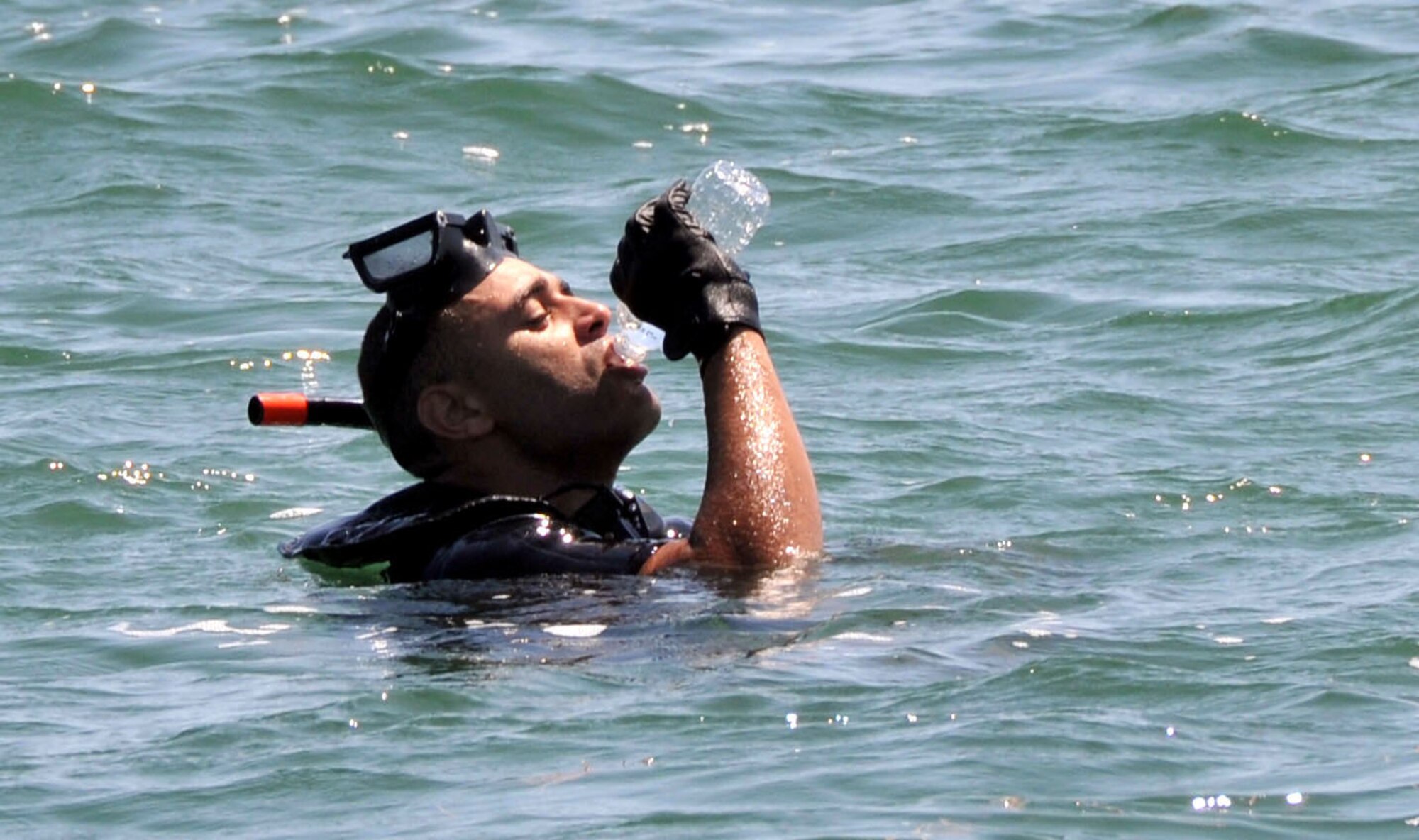 AW2 Enrique Davis, Navy rescue swimmer, NAS Key West, Fla., empties a bottle of water during water survival training for dozens of 934 AW members.  