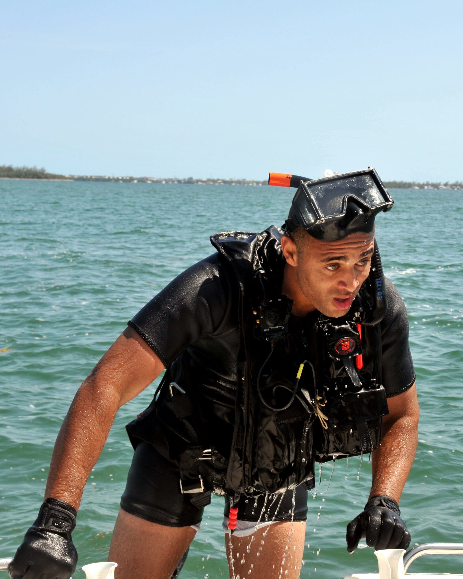 AW2 Enrique Davis, Navy rescue swimmer at NAS Key West, Fla., climbs aboard the shuttle boat after completing helicopter hoist training for dozens of 934 AW members.(Air Force Photo/Master Sgt. Kerry Bartlett)