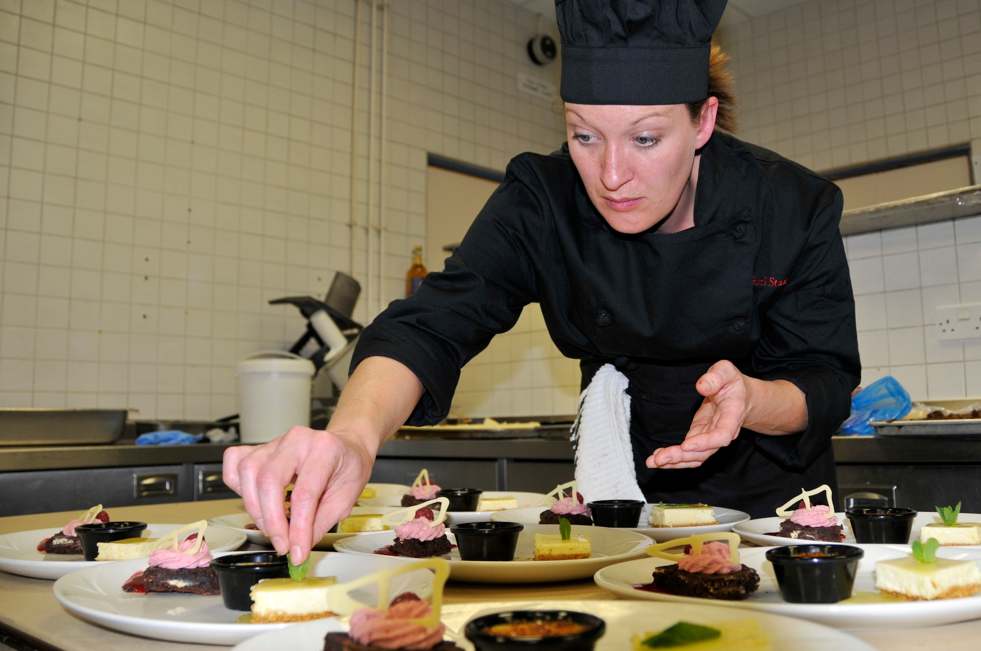 ROYAL AIR FORCE LAKENHEATH, England --Ruth Stamp, 48th Force Support Squadron Liberty Club chef, puts the finishing touches on her desserts April 25, 2009. Cooks and chefs from the Knight's Table and the Liberty Club competed for the title of top chefs during the "Hell's Kitchen" competition. (U.S. Air Force photo by Airman 1st Class Perry Aston)