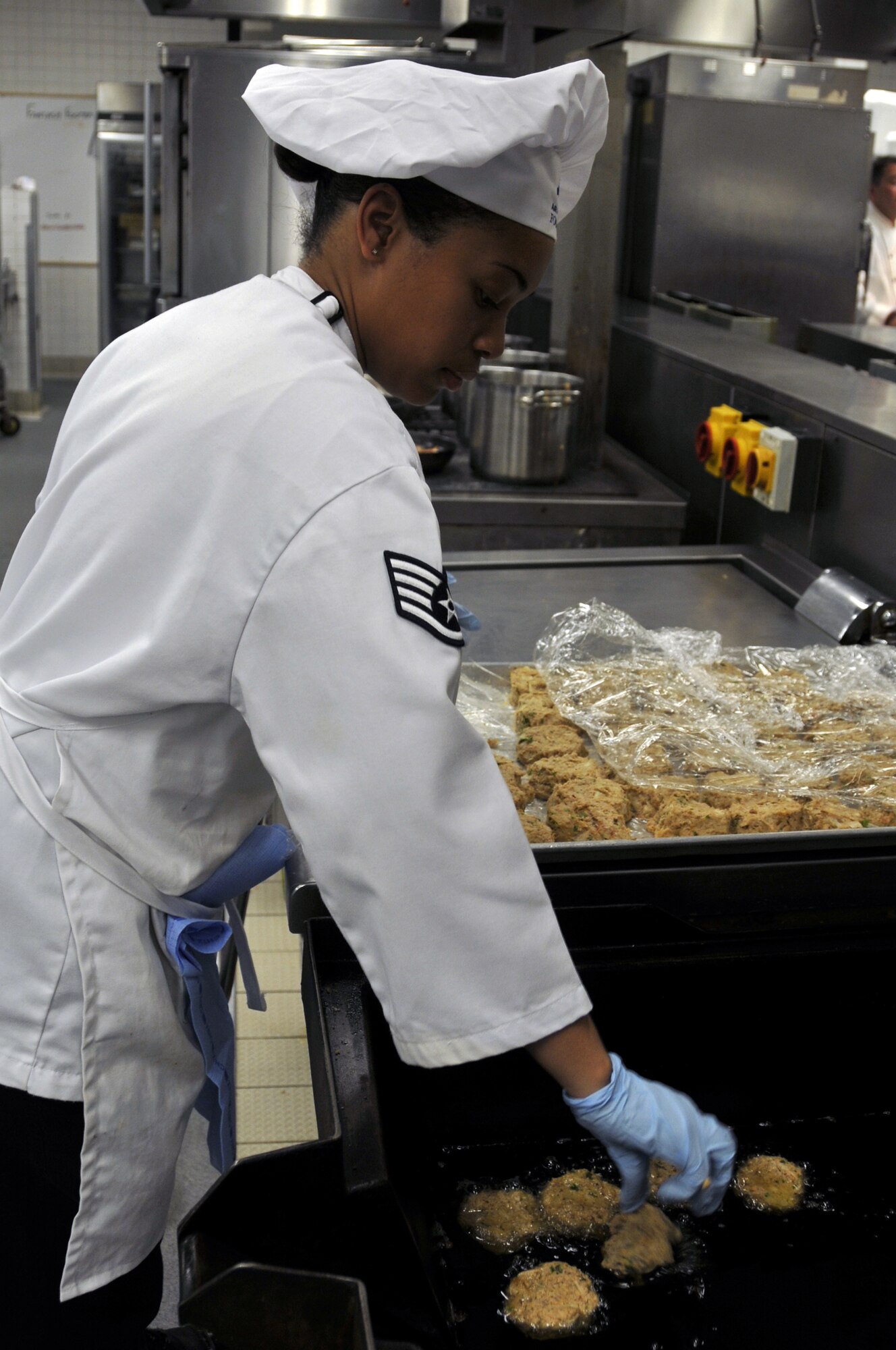 ROYAL AIR FORCE LAKENHEATH, England -- Staff Sgt. Kiana Mobley, 48th Force Support Squadron cook, drops crab cakes into the fryer at the Liberty Club April 25, 2009. Cooks and chefs from the Knight's Table and the Liberty Club competed for the title of top chefs during the "Hell's Kitchen" competition. (U.S. Air Force photo by Airman 1st Class Perry Aston)