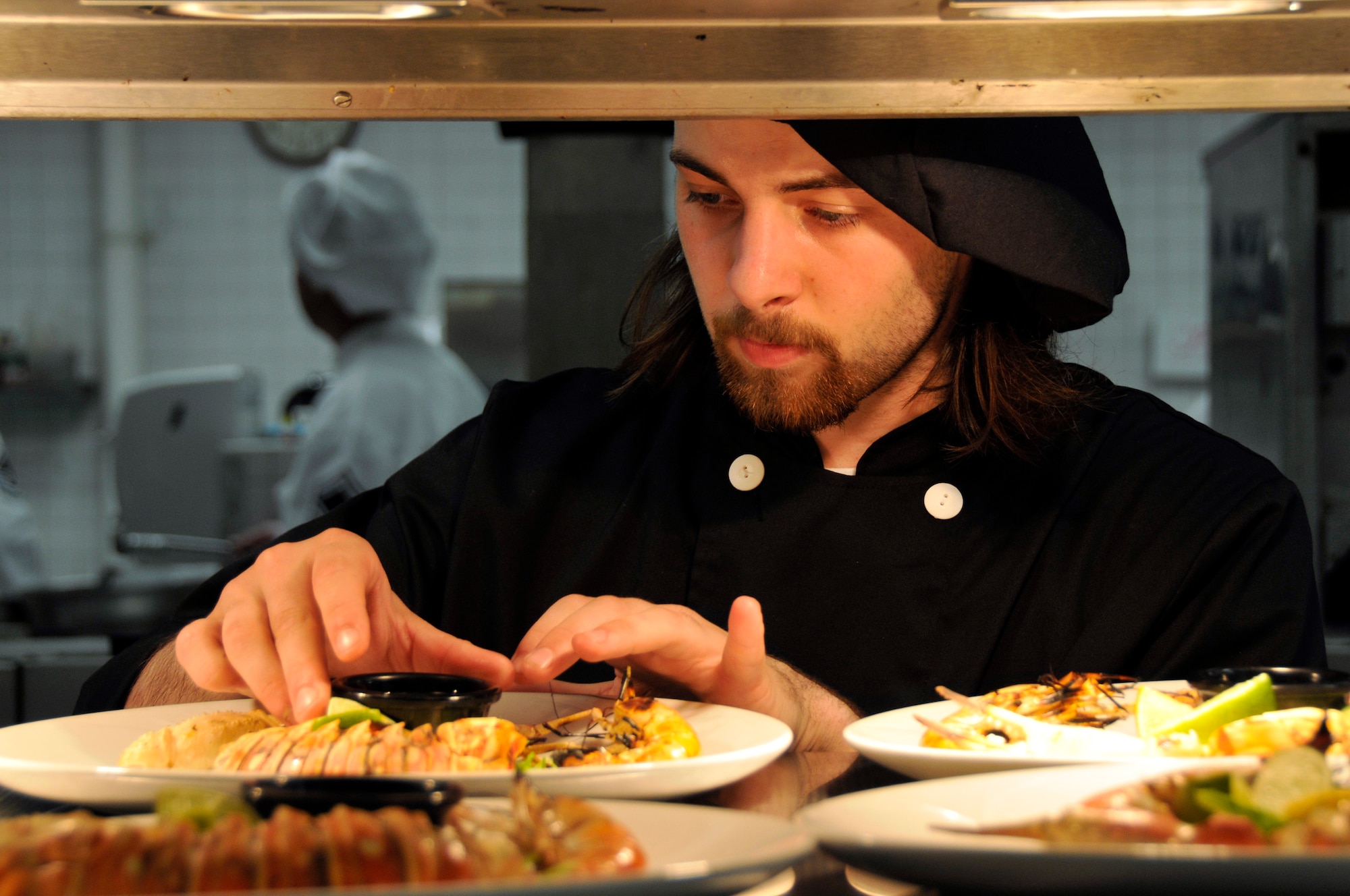 ROYAL AIR FORCE LAKENHEATH, England -- Richard Bragg, 48th Force Support Squadron Liberty Club cook, places ramekin of melted butter for the sea food platter April 25, 2009. Cooks and chefs from the Knight's Table and the Liberty Club competed for the title of top chefs during the "Hell's Kitchen" competition. (U.S. Air Force photo by Airman 1st Class Perry Aston)