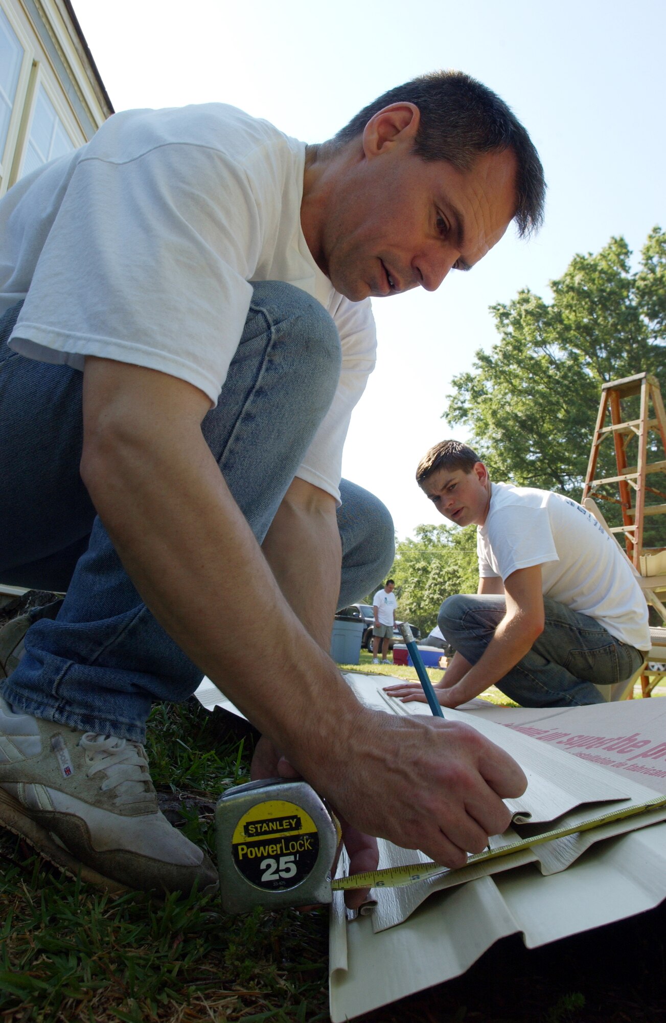 Lt. Col. Anthony Polashek and his son, Zack, measure siding Saturday. Rebuilding Together assists low-income homeowners with repairs they would not otherwise be able to accomplish on their own. More than 85 members, including family and friends, of Headquarters, Air Force Reserve Command, Robins Air Force Base, Ga., turned out for the event.