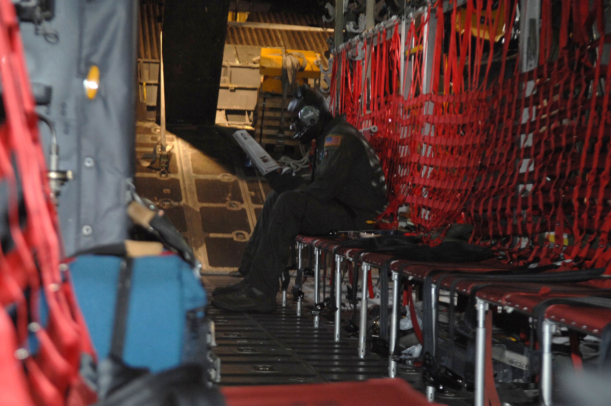 United States Air Force Staff Sgt. Corey Long, 37th Airlift Squadron loadmaster, relaxes before landing in Grafenwoehr, Germany, April 22, 2009. This is the final large airdrop with the 173rd Airborne Brigade Combat Team that the C-130E Hercules will make. The C-130J model will be used for jumps in the future. (U.S. Air Force photo by Tech. Sgt. Michael Voss)