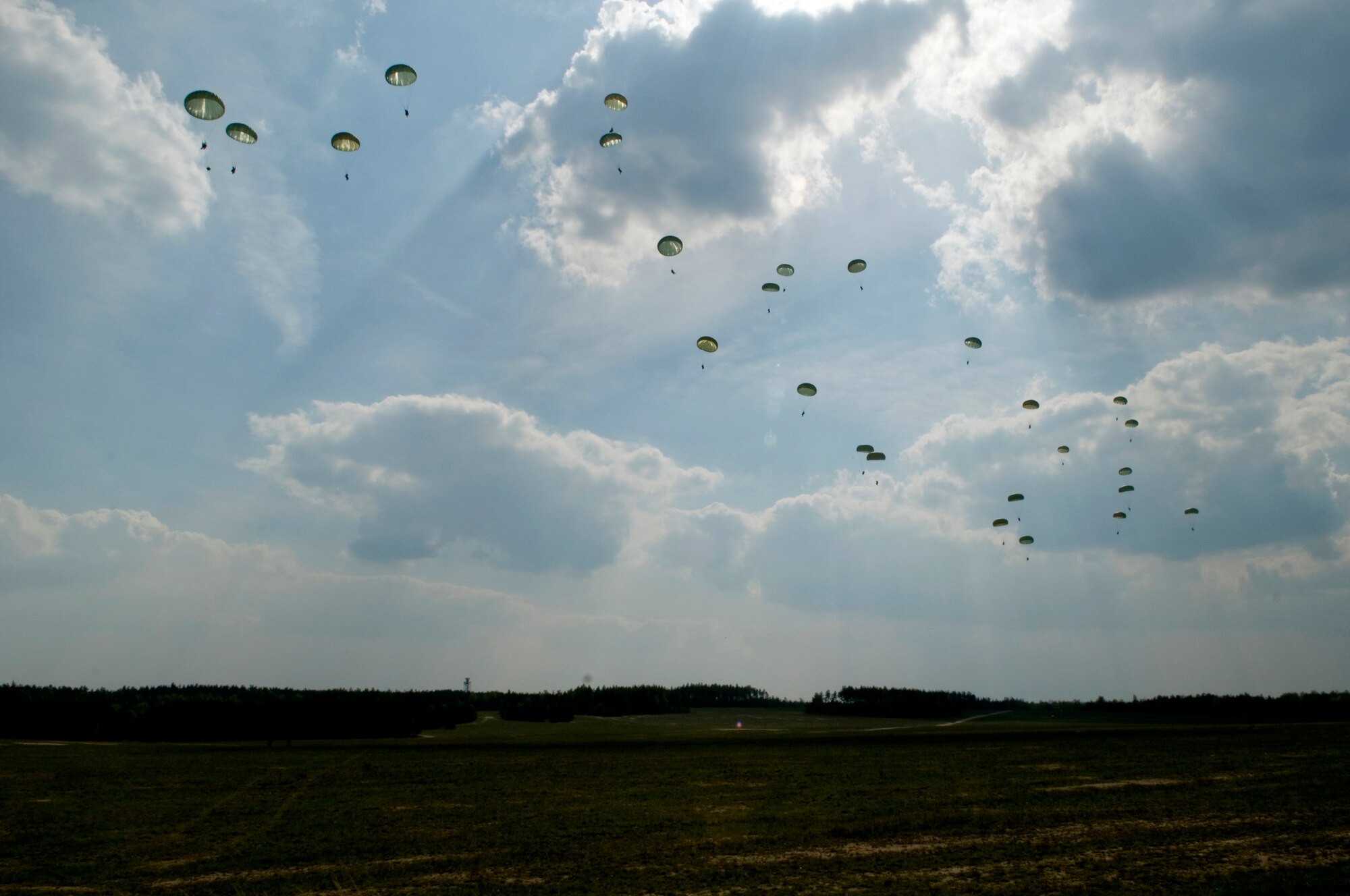 Members of the U.S. Army 173rd Airborne Brigade Combat Team float safely the ground after jumping out of a C-130E Hercules, April 22, 2009, Grafenwoehr Army Airfield, Germany. This is the last large combat training drop for a C-130E in Germany. (U.S. Air Force photo by Senior Airman Nathan Lipscomb)