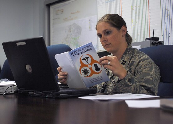 Captain Kylie Maclellan, 4th Aerospace Medicine Squadron, reviews hazardous-materials information in the emergency operations center during a training exercise at Seymour Johnson Air Force Base, N.C., April 21, 2009. As the officer in charge of the squadron's bioenvironmental engineering flight, Captain Maclellan is one of the commander's primary advisors on chemical and biological threats. During the exercise, the captain provided direction to a hazardous materials response team as they investigated a suspicious package and relayed the team's findings to the operations center's leadership.  (U.S. Air Force photo by Staff Sgt. Shawn J. Jones)