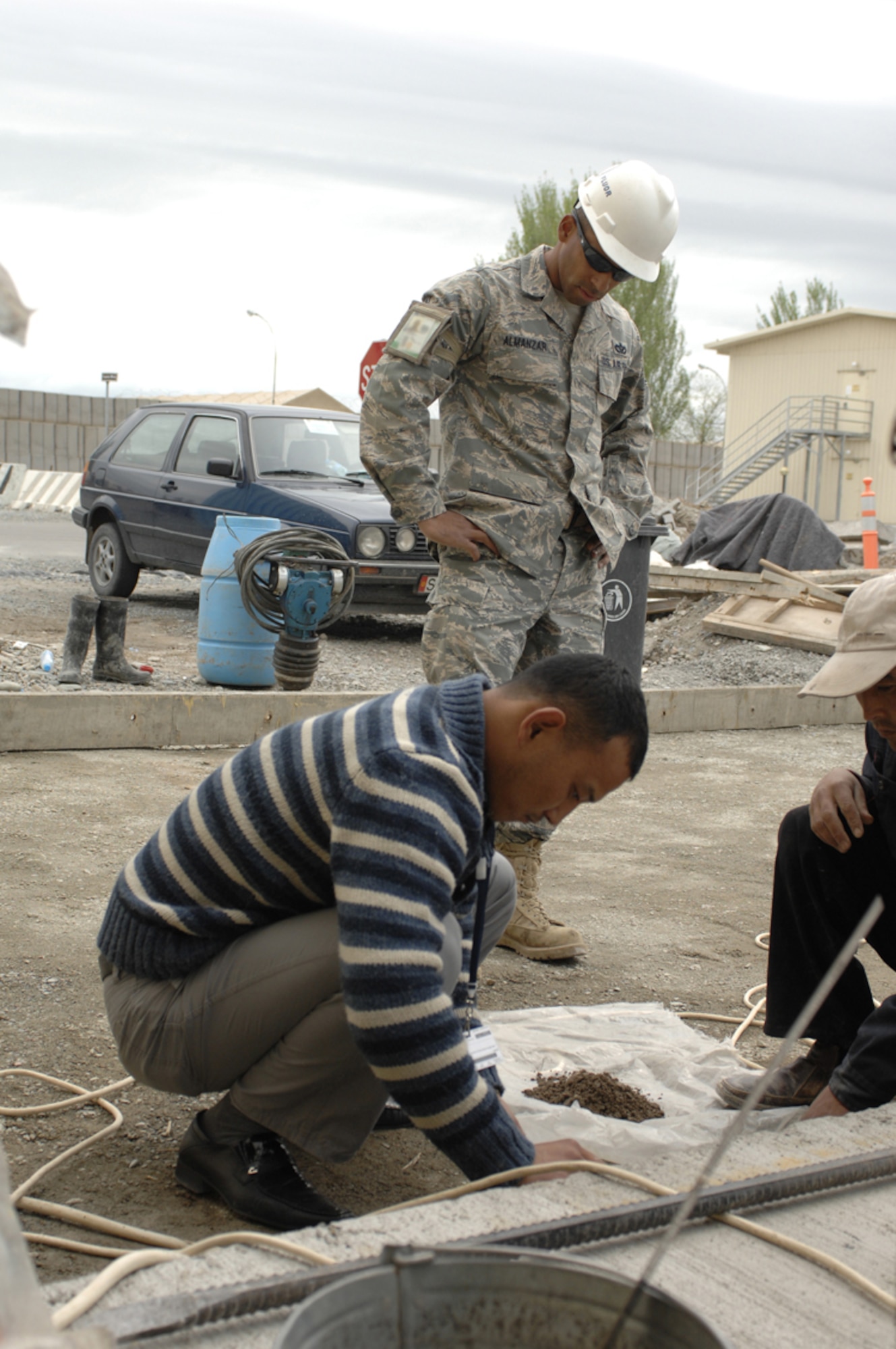 Staff Sgt. Johan Almanzar, construction manager, observes a sand cone test being conducted by Kyrgyz construction workers at Manas Air Base, Kyrgyzstan, April 27. Sergeant Almanzar, assigned to the 376th Expeditionary Civil Engineer Squadron and is deployed from 1st Special Operations Civil Engineer Squadron at Hurlburt Field, Fla. He is a native of the Bronx, N.Y. (U.S. Air Force photo/Master Sgt. Charles M. Wade)