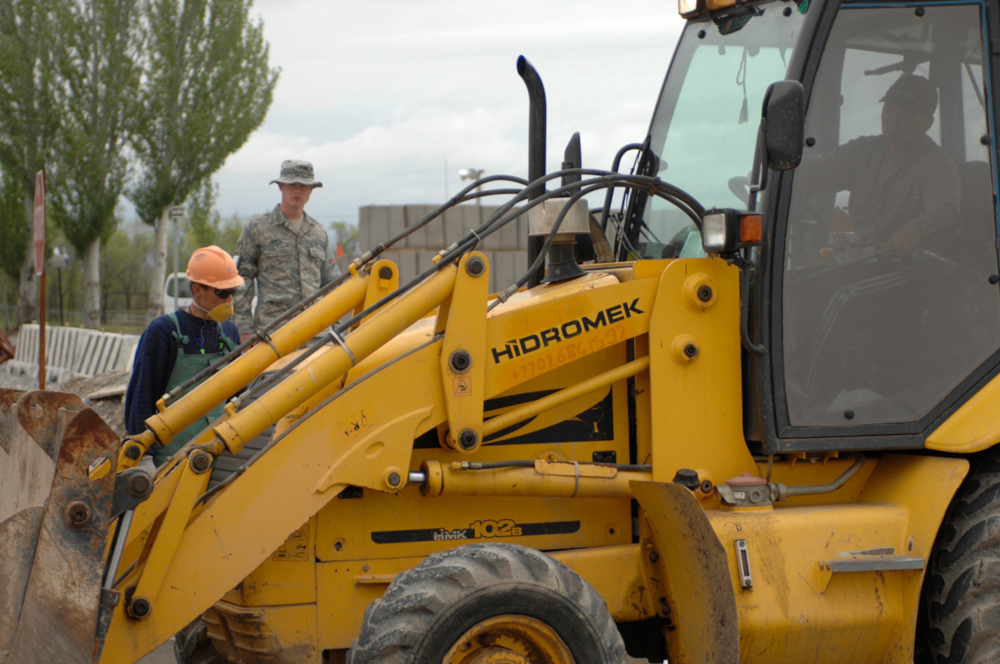 Senior Airman Theodore Smith observes Kyrgyz construction workers as they continue construction on the new fire station at Manas Air Base, Kyrgyzstan, April 27. The fire station is projected to be complete around May 15 and will replace a tent station that has been used for more than seven years. It will provide shelter for two trucks, offices and living quarters for firefighters on duty. Airman Smith is a host nation escort assigned to the 376th Expeditionary Civil Engineer Squadron. He is deployed from Elmendorf Air Force Base, Ala., and is a native of Chapin, S.C. (U.S. Air Force photo/Master Sgt. Charles M. Wade) 
