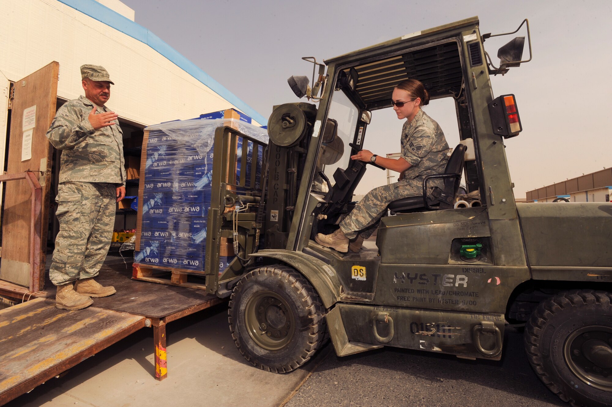 Master Sgt. Brian Jusczyk, the Somerset Dining Facility manager with the 379th Expeditionary Force Support Squadron, spots Senior Airman Chandra Wostenberg, a services journeyman also with the 379th Expeditionary Force Support Squadron, as she delivers a pallet of water to the Somerset Dining Facility here, April 27, 2009 in an undisclosed location in Southwest Asia.  Food and beverages are constantly re-stocked to ensure the facility is able to serve all personnel.  Sergeant Jusczyk is native to Coventry, R.I. and is deployed from North Smith Field, Rhode Island Air National Guard, while Airman Wostenberg hails from Worland, Wyoming and is deployed from the Wyoming Air National Guard, both in support of Operations Iraqi and Enduring Freedom, and Combined Joint Task - Force Horn of Africa.  (U.S. Air Force Photo by Staff Sgt Joshua Garcia/released)