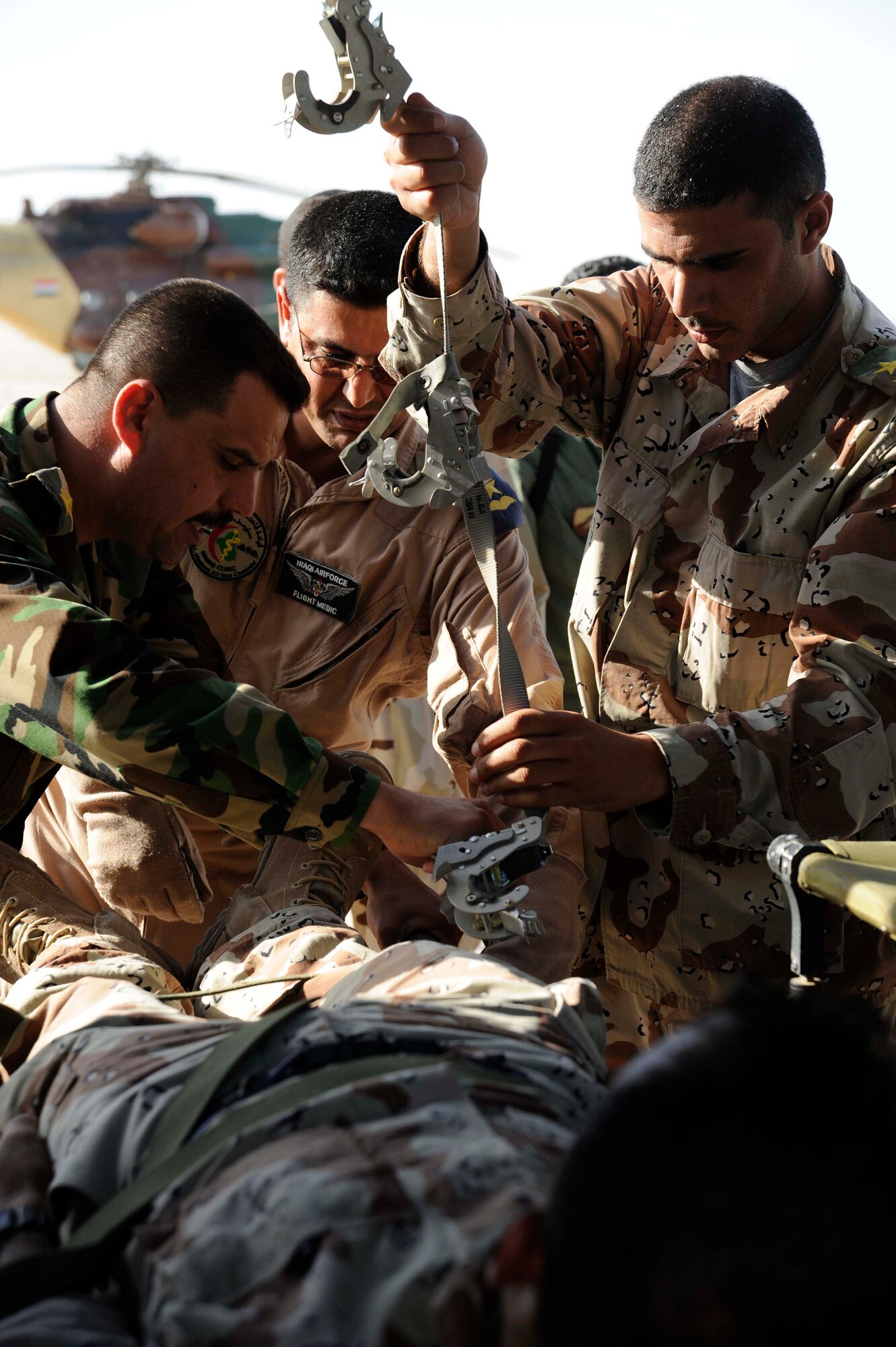 Lieutenant Amar instructs Iraqi air force and Iraqi army members how to strap in a person on a litter inside a UH1 Huey helicopter during the aero-medical evacuation class at the Flight Surgeon course at New al-Muthana Air Base, Iraq April 20, 2009. The training is teaching the Iraqis how to convert a UH-1 Huey Helicopter and a C-130 Hercules Aircraft from a passenger transport to an aero-medical evacuation medevac transport. This is the third class of Iraqi flight surgeons that will be graduating from the four week course.  The course, which is currently taught by Iraqi flight surgeons and the Coalition Air Force Training Team will be 100 percent taught by the Iraqis during the next course.  After completing the course the Iraqi officers are going to be responsible for doing physicals on candidates that want to fly in the Iraqi forces and taking care of the current aircrew members. Lieutenant Amar is a flight nurse at New al-Muthana Air Base clinic.  (U.S. Air Force photo by Senior Airman Jacqueline Romero)