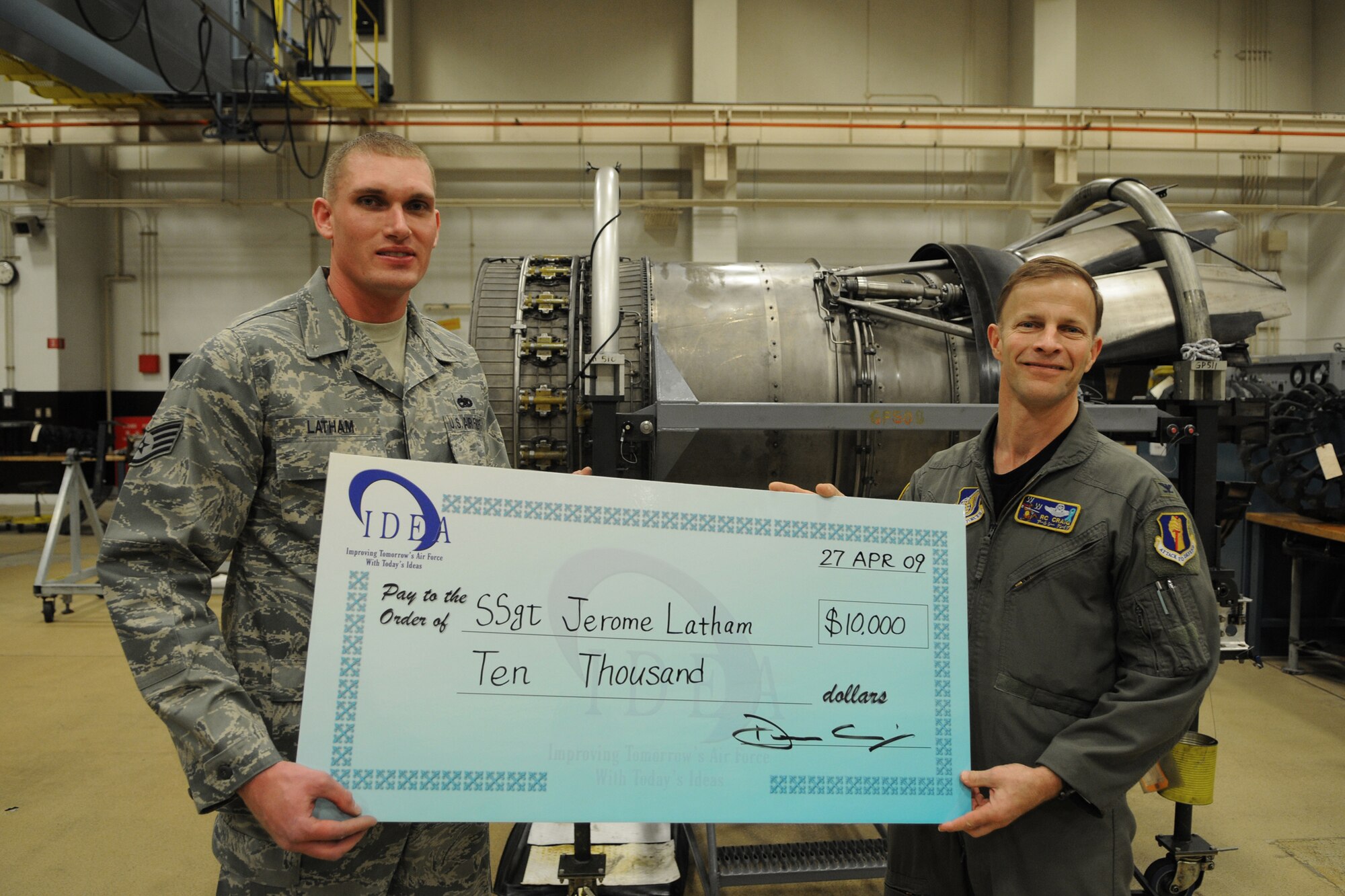 MISAWA AIR BASE, Japan -- Staff Sgt. Jerome Latham, 35th Maintenance Squadron, receives a $10,000 check from Col. Robert Craig, 35th Fighter Wing vice commander, courtesy of the Innovative Development through Employee Awareness program April 27, 2009. The IDEA program rewards Airmen for ideas that save Air Force money and resources. (U.S. Air Force photo by Senior Airman Jamal Sutter)