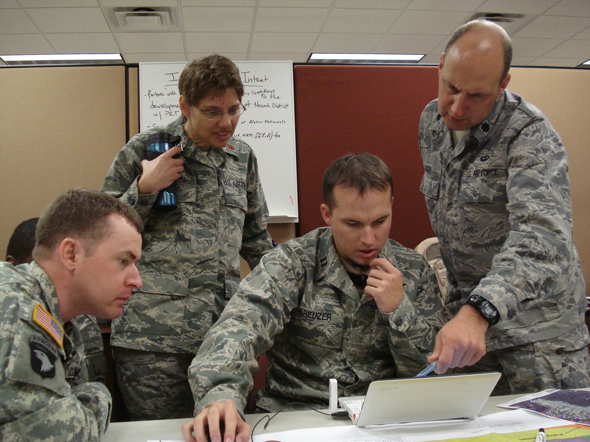 U.S. Air Force Lt. Col. W. Mark Heiser, far right, reviews an electronic map of Afghanistan with members of the Parwan Provincial Reconstruction Team, from left U.S. Army Capt. Chris Kidd, U.S. Air Force Maj. Lori Adams, and Capt. Michael Kreuzer. PRTs are assembled at Camp Atterbury, Ind., to learn about how to support local communities in Afghanistan through construction and agricultural projects. (U.S. Air Force photo by Capt. Darrick Lee) 