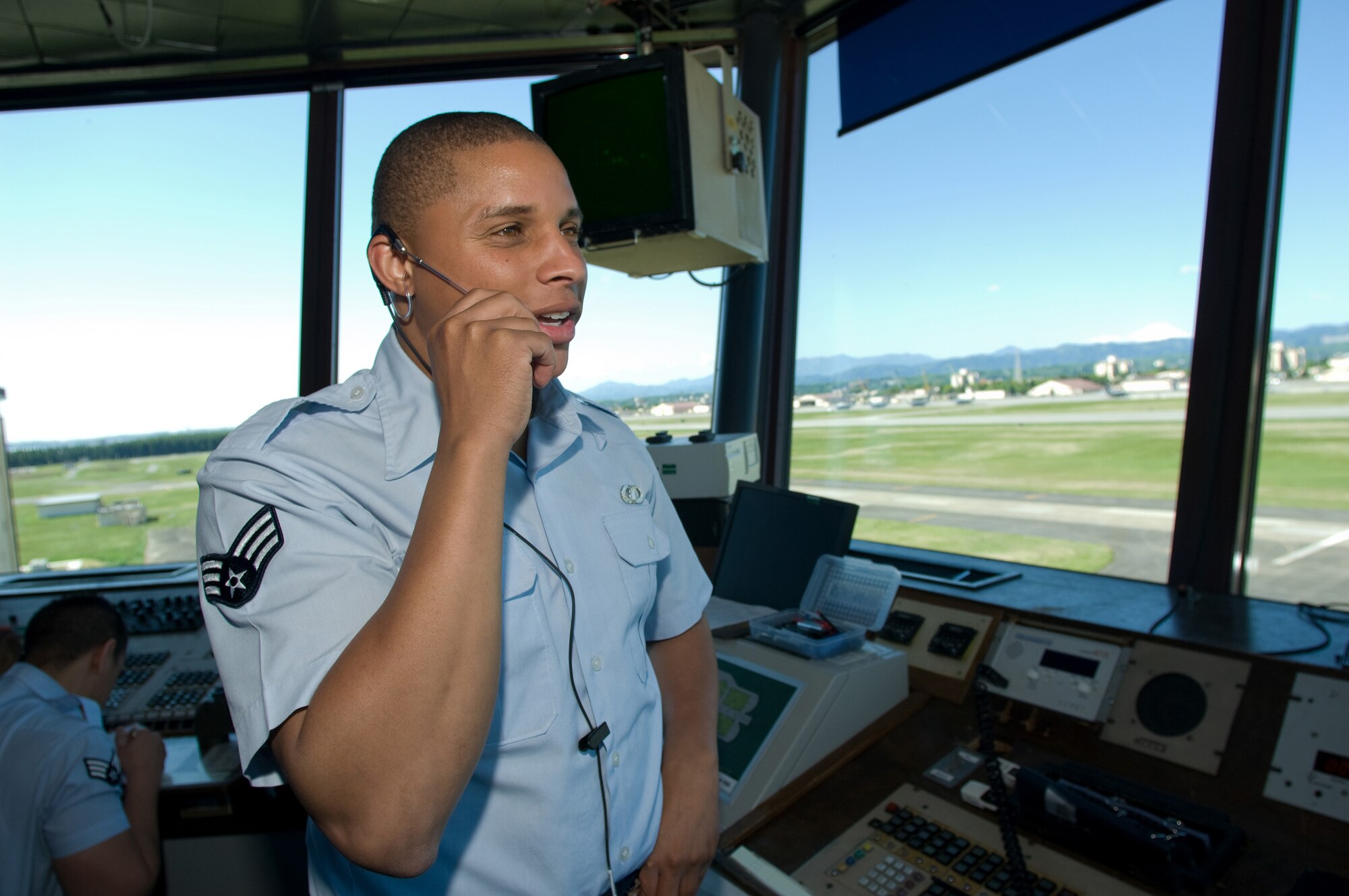 YOKOTA AIR BASE, Japan -- Senior Airman Nissean Johnson, 374th Operations Support Squadron air traffic controller, communicates with an aircrew on the flightline here. Radar approach control facility and tower personnel will move to a new facility in November. Workers are currently setting up new equipment in the facility, which replaces a control tower and RAPCON in use since the 1960s. (U.S. Air Force photo/Osakabe Yasuo)