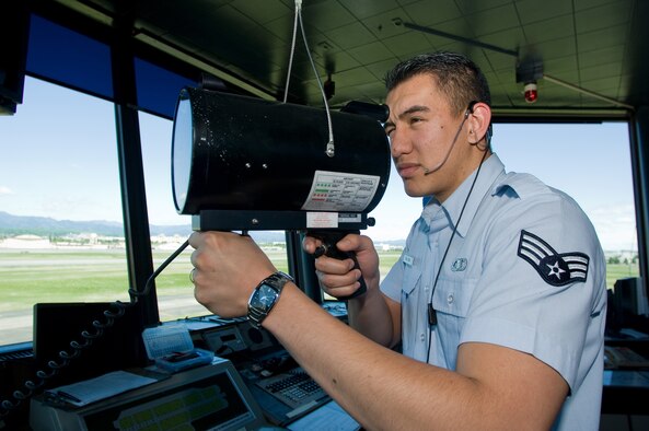 Senior Airman James Dela-Pena uses a light gun to signal traffic crossing the active runway at Yokota Air Base, Japan. Radar approach control facility and tower personnel will move to a new facility in November. Workers are currently setting up new equipment in the facility, which replaces a control tower and RAPCON in use since the 1960s. Airman Dela-Pena is an air traffic controller with the 374th Operations Support Squadron. (U.S. Air Force photo/Osakabe Yasuo) 