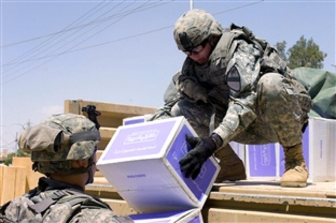 U.S. Army Spc. Michael Perkins, right, hands boxes filled with books to a fellow soldier in Kirkuk, Iraq, April 26, 2009. Perkins is assigned to the 1st Calvary Division's, Troop C, 4th Squadron, 9th Cavalry Regiment, 2nd Heavy Brigade Combat Team.