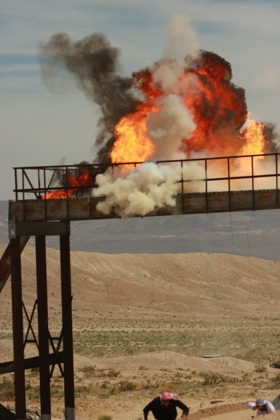 A mock improvised explosive device explodes as role players with the Advisor Training Group begin a scenario for transition teams going through their mission rehearsal exercise May 1 at the Combat Center’s Gypsum Ridge.
