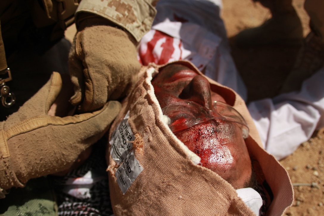 Petty Officer 2nd Class Anthony Kaer, a corpsman partaking training with the Advisor Training Group, attends to a casualty May 1 after the team encountered a fake improvised explosive device during a patrol in the Combat Center’s Gypsum Ridge training area.