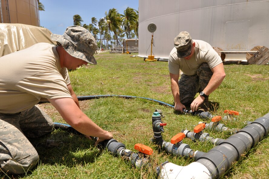 ROI-NAMUR, Marshall Islands - Civil Engineer Airmen work to connect tubes to water tanks to replenish the water supply here that was ruined by unusually high tides in the early part of February. The Airmen have treated more than 1,840,000 gallons of water since their arrival on Feb. 4, 2009. Three of the team members are from Kadena Air Base, Japan, and three are from Eielson Air Force Base, Alaska. (U.S. Air Force photo/Tech. Sgt. Cohen A. Young)
