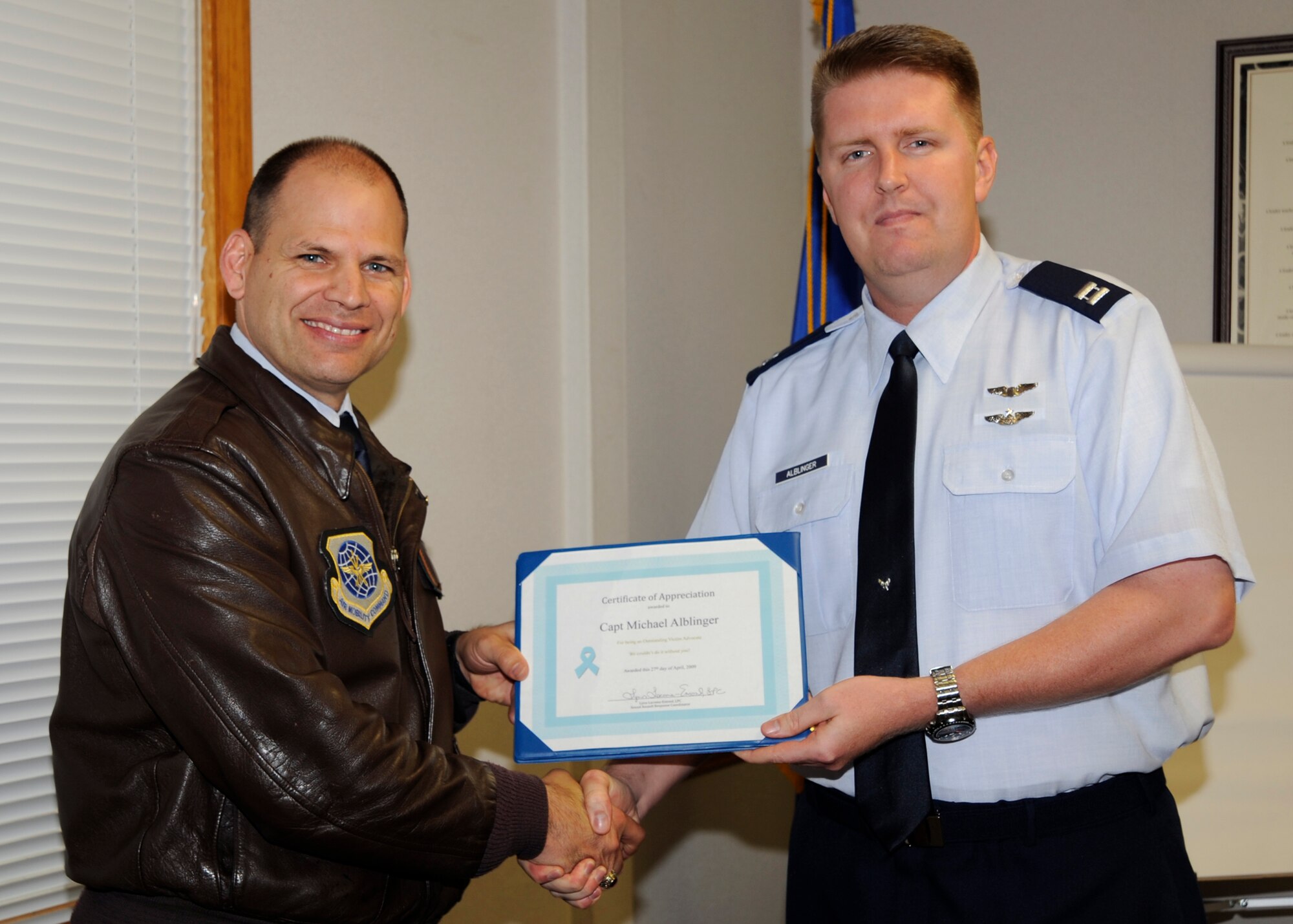 MCCONNELL AIR FORCE BASE, Kan. -- Capt. Michael Alblinger, 349th Air Refueling Squadron, receives a certificate of appreciation from Col. James C. Vechery, 22nd Air Refueling Wing commander, for volunteering his personal time as a Sexual Assault Victim Advocate, April 27. Staff Sgt. Philip Simon, Tech. Sgt. Doug Wilson, 22nd Air Refueling Wing, Roberta McGrew and Capt. Melissa Alblinger, 22nd Force Support Squadron, were also recognized for their dedicated service as victim advocates. (Photo by Airman 1st Class Justin Shelton)