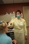 Retired Lt. Col. Kathy Hagerman, a pediatric nurse practitioner, takes the temperature of a patient at the 12th Medical Group April 29. Ms. Hagerman was the first to perform a throat culture on two teenagers suspected of contracting the H1N1 , or swine, influenza recently. U.S. Air Force photo by Steve White)
