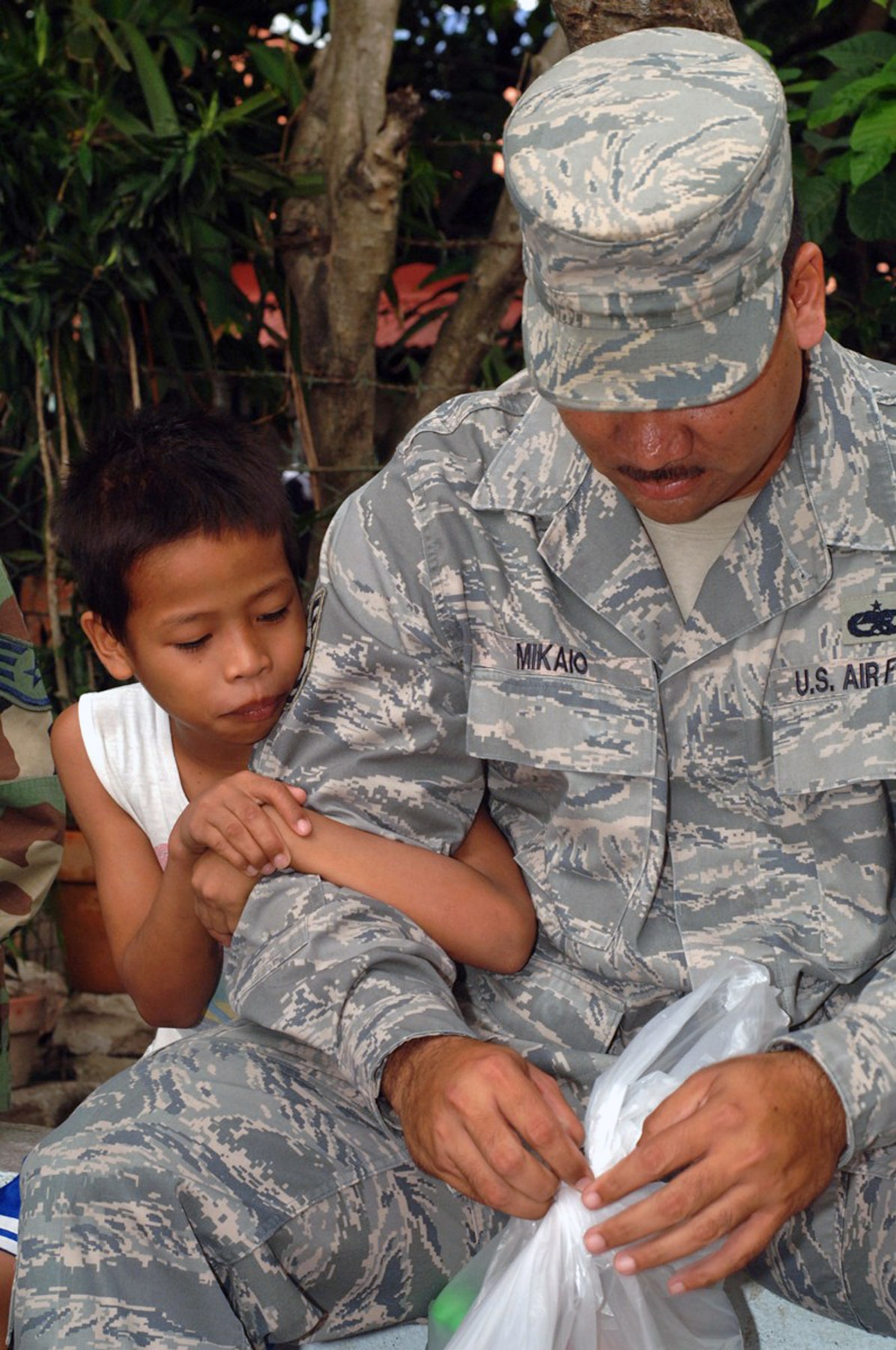 Tech. Sgt Jeffery Mikaio makes a new friend during a visit to a Filipino orphanage where more than 20 Airmen donated schools supplies, athletics equipment and toys April 25 at Angeles City, Philippines. Sergeant Mikaio is assigned to the 63rd Fighter Squadron from Luke Air Force Base, Ariz. (U.S. Navy photo/Petty Officer 2nd Class Robert Clowney) 
