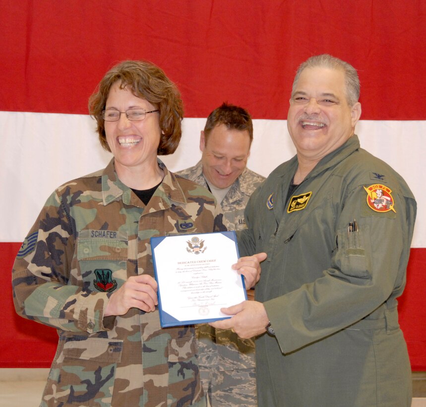Tech. Sgt. Carolyn Schafer, left, accepts a dedicated-crew-chief certificate from Col. Mark Clemons, the 442nd Fighter Wing commander, during a dedicated-crew-chief ceremony April 4, 2009, in the wing's 5-Bay maintenance hangar.  Sergeant Schafer and her fellow crew chiefs in the 442nd Aircraft Maintenance Squadron were honored in a ceremony to recognize the importance of crew chiefs in the operation and maintenance of the wing's A-10 Thunderbolt II aircraft.  Crew chiefs' names are painted on the sides of the wing's A-10s signifying the responsibility each one has for the wing's 27 airplanes.  The 442nd Fighter Wing is an Air Force Reserve Command unit based at Whiteman Air Force Base, Mo.  (U.S. Air Force photo/Master Sgt. Bill Huntington)