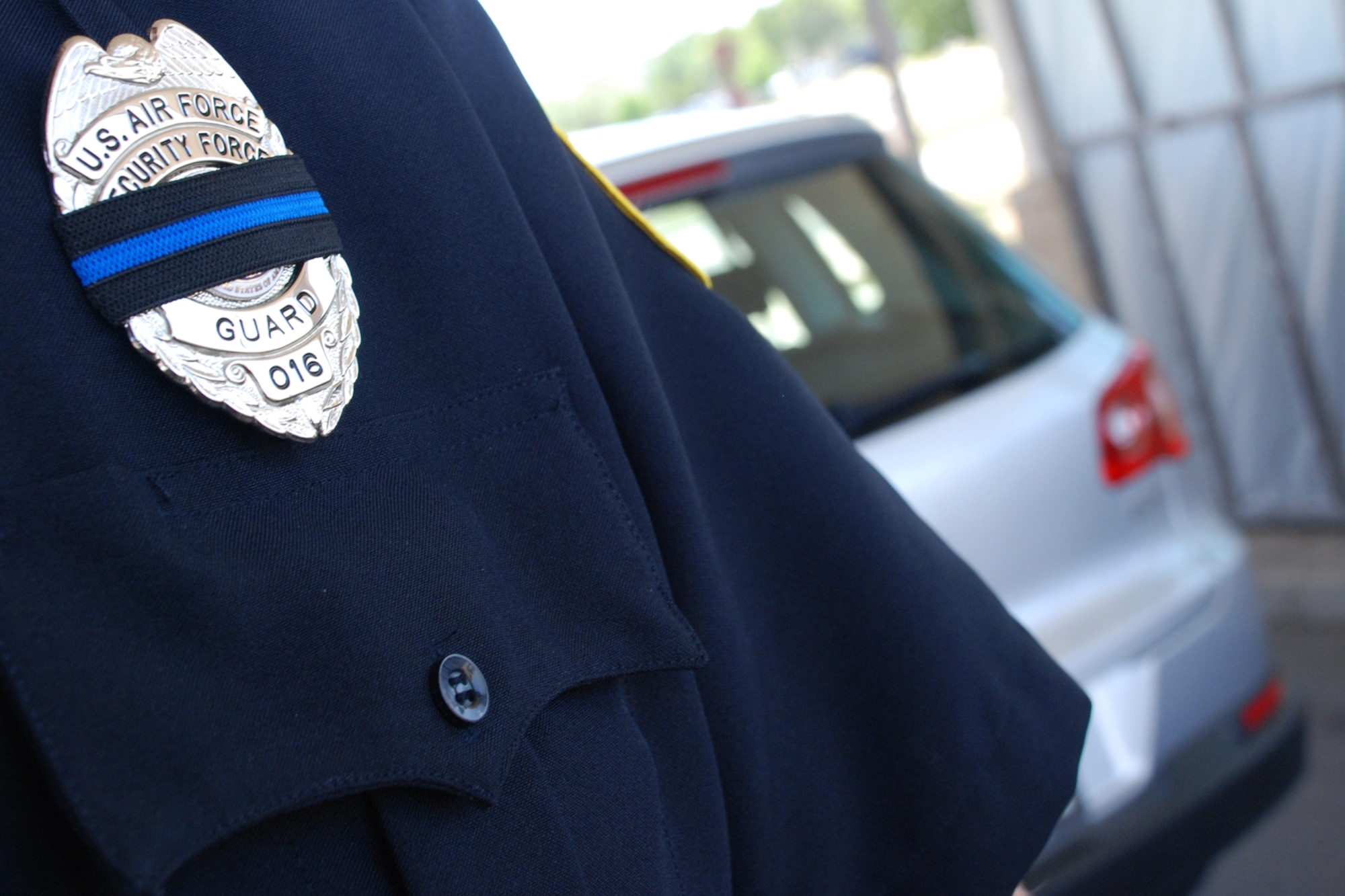 EGLIN AIR FORCE BASE, Fla. -- Officer Mike Bearden, an Eglin Department of the Air Force security guard, wears a black band with a blue strip over his badge to honor two Okaloosa County Sherriff Deputies who were killed in the line of duty April 25. The black of the band signifies the death while the blue strip signifies it was a police officer. Law enforcement agencies wear the a badge, shield or star as a sign of respect and honor. Deputy Warren "Skip" York, one of the officers killed, retired from the Air Force as a member of the 96th Security Forces Squadron, Eglin Air Force Base, Fla. He served with the Okaloosa County Sheriff's Office for six years. He is survived by his wife and children. Deputy Burt Lopez was also a retired military servicemember. (U.S. Air Force photo/Staff Sgt. Mike Meares)