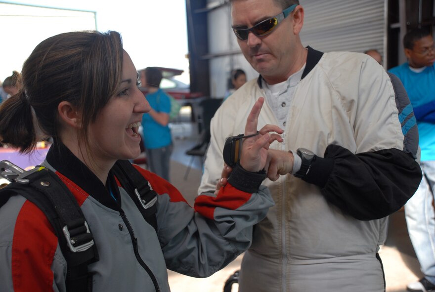 Skydiving instructor Maj. Holt Durham, Det. 5, helps Capt. Michelle Willison, 7th Space Warning System, gear up before making a tandem skydiving jump at the Lincoln Airport April 24. Captain Willison was one of 36 Beale members who participated in the  Jump Into Prevention day hosted by Beale's Sexual Assault Awareness Coordinator in honor of sexual assault prevention month. (Photo by Staff Sgt. Sarah Gregory)