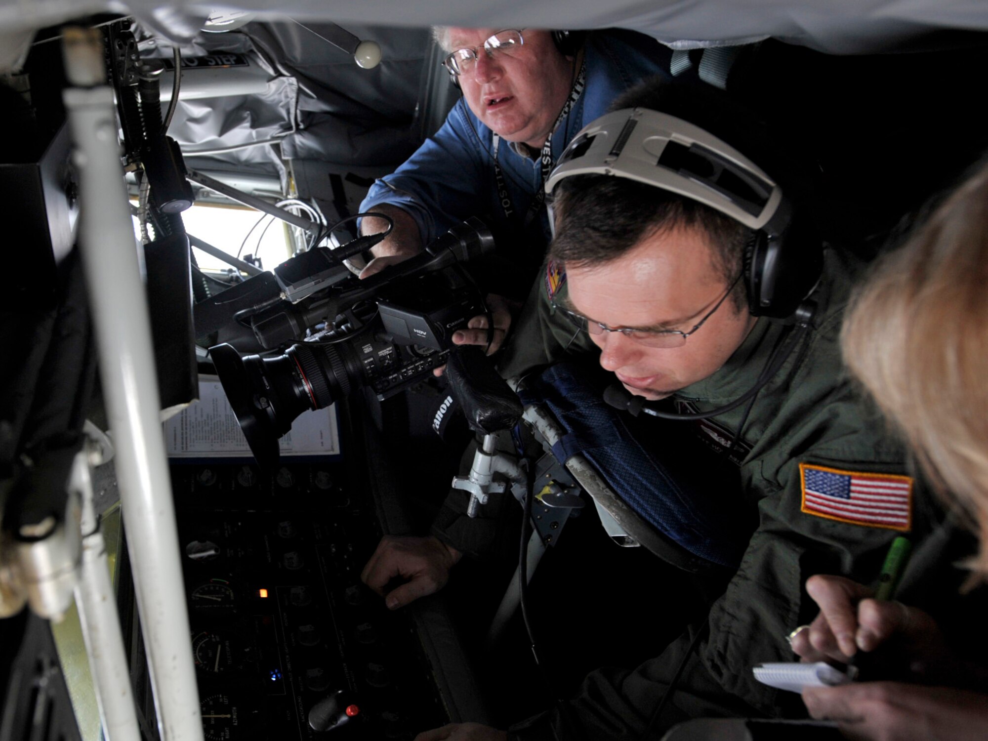 Bo Rader, newspaper photojournalist, films through the rear window of a KC-135 Stratotanker's boom pod during an aerial refueling training mission on April 28. Mr. Rader and a writer from the Wichita Eagle, a daily newspaper in Wichita, Kan., travelled with representatives from the 931st Air Refueling Group and the 22nd Air Refueling Wing to Tinker Air Force Base, Okla., to tour a depot where KC-135s are rebuilt. Tech. Sgt. Jeff Hollaway (pictured) was the boom operator of the 22nd ARW crew that flew the KC-135 to Tinker. The 931st is an Air Force Reserve unit and the 22nd is its active-duty host unit at McConnell Air Force Base, Kan. (U.S. Air Force photo/Tech. Sgt. Jason Schaap)