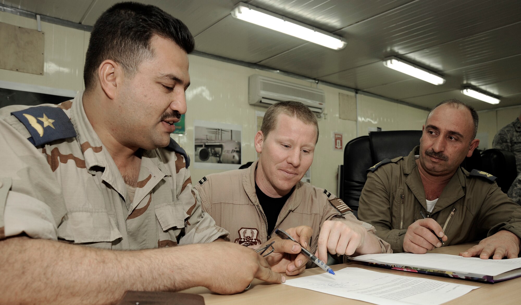 Capt. Justin Allen plans out air operations with Iraqi air force 2nd Lt. Firas and Maj. Muaamur Fuad April 21 at Camp Victory, Iraq. Major Fuad and Lieutenant Firas are part of 10 Iraqi air force officers receiving the first course of U.S. Joint Air Operations Planning. Captain Allen is deployed from Tyndall Air Force Base, Fla. and a native of Pryor, Okla. (U.S. Air Force photo/Senior Airman Jacqueline Romero) 
