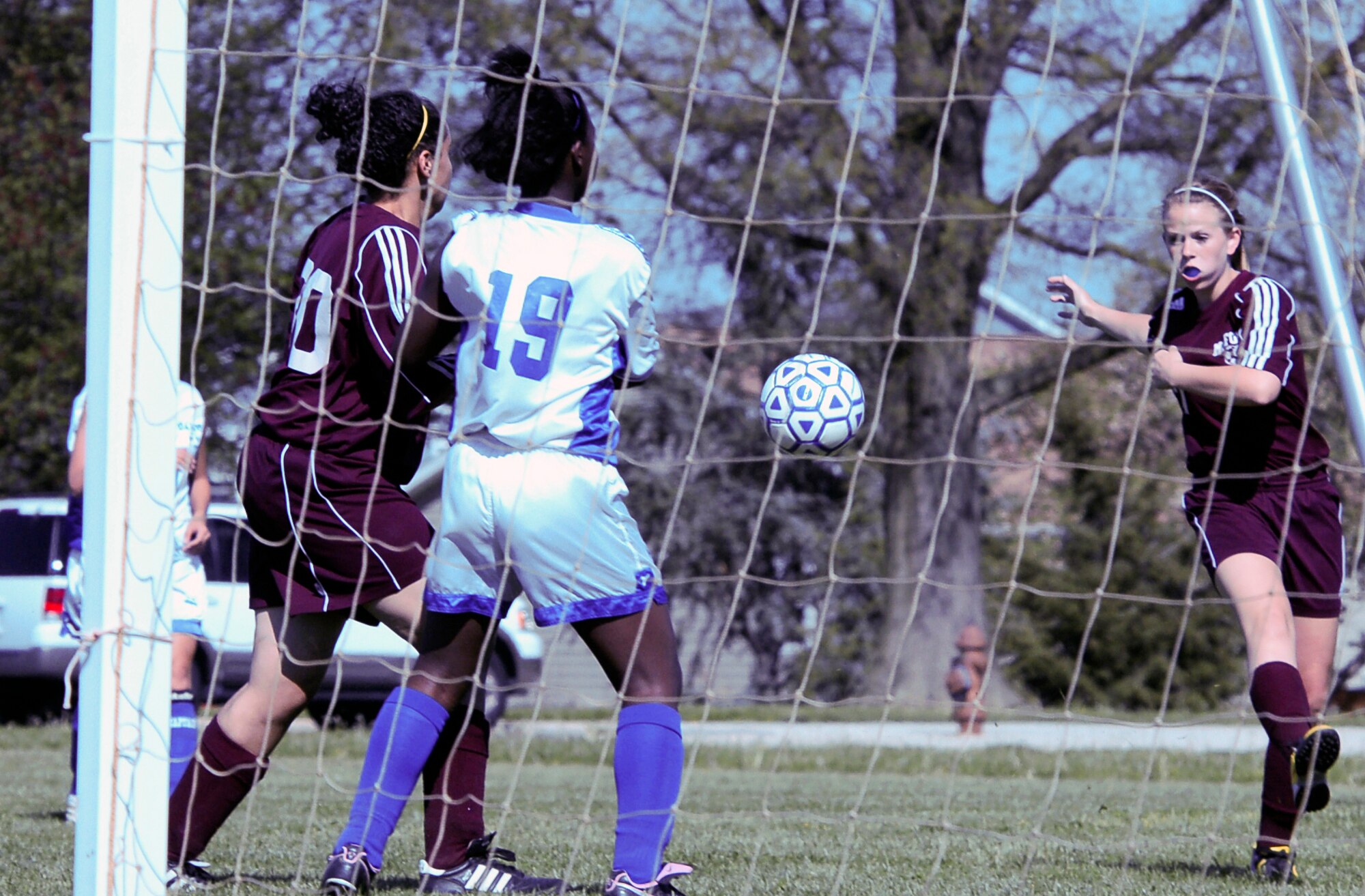 Angie Glasting (right), Milford Middle School Buccaneer forward, takes a shot on goal as Air Base Middle School defender Aisha Hallman (center), steps up to assist the Falcon?s keeper, Autumn Williams, in blocking the shot April 27. Despite their rally on defense, the Falcons lost the game 5 ? 0. (U.S. Air Force photo/Tech. Sgt. Kevin Wallace)