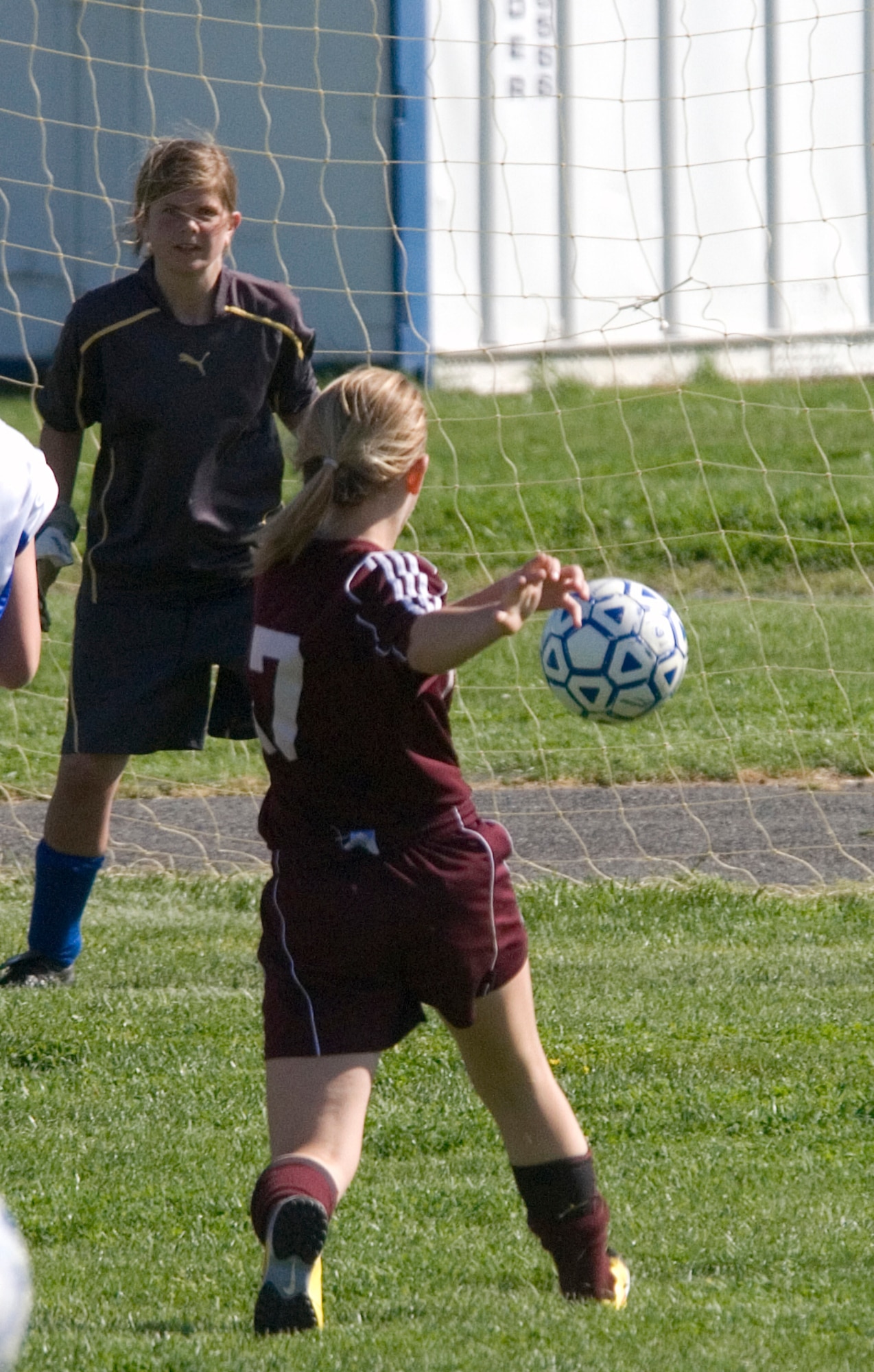 Jaimey Rouse, Milford Middle School Buccaneer forward, takes a shot on goal as Autumn Williams, Air Base Middle School Falcon?s keeper, judges the shot and prepares to attempt to block the shot during a game played at Dover Air Force Base April 27. Williams has been playing soccer for two years and is the Falcon starting keeper. (U.S. Air Force photo/Tech. Sgt. Kevin Wallace)