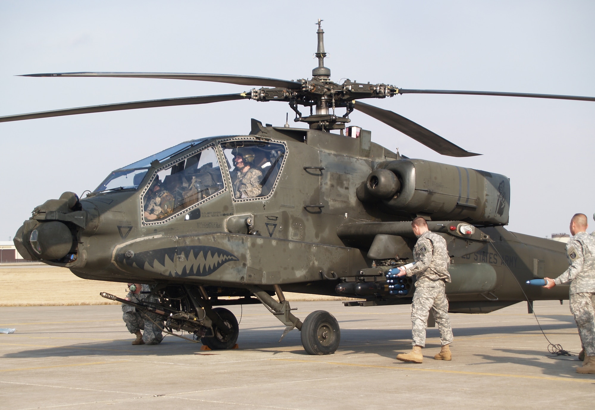 Col. John Anderson, 35th Combat Aviation Brigade commander, loads a folding fin aerial rocket into the Apache gunship, while Maj. John Martin, 1-135th Attack Reconnaisance Battalion administrative officer, waits for his turn at the task. (Photo by Rachel Knight/Missouri National Guard)