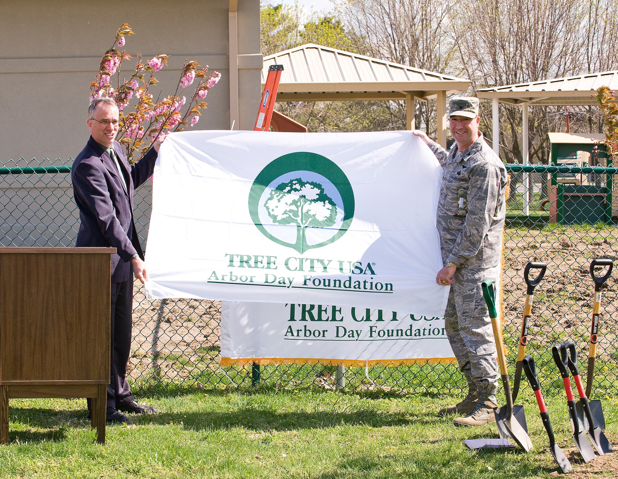 Austin Short, Delaware State forester, and Col. Todd Emmert, 436th Mission Support Group commander, display a Tree City USA banner to signify Dover Air Force Base being named a Tree City USA April 23. This is the 17th year Dover AFB has received national recognition for its urban and community forestry programs. (U.S. Air Force photo/Tom Randle)