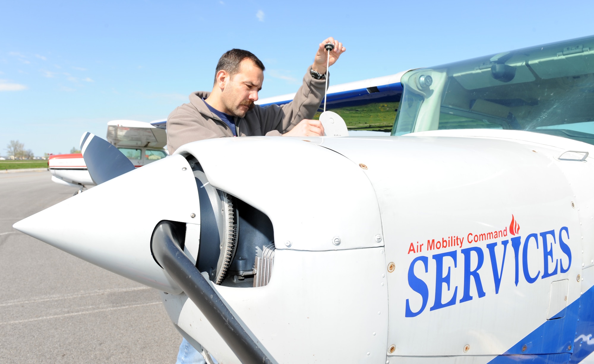 SCOTT AIR FORCE BASE, Ill. --As part of the pre-flight inspection, Mr. Tucker checks the oil in the Cessna 152. A pre-flight inspection takes about 15 minutes. (U.S. Air Force photo/Staff Sgt. Paul Villanueva II)