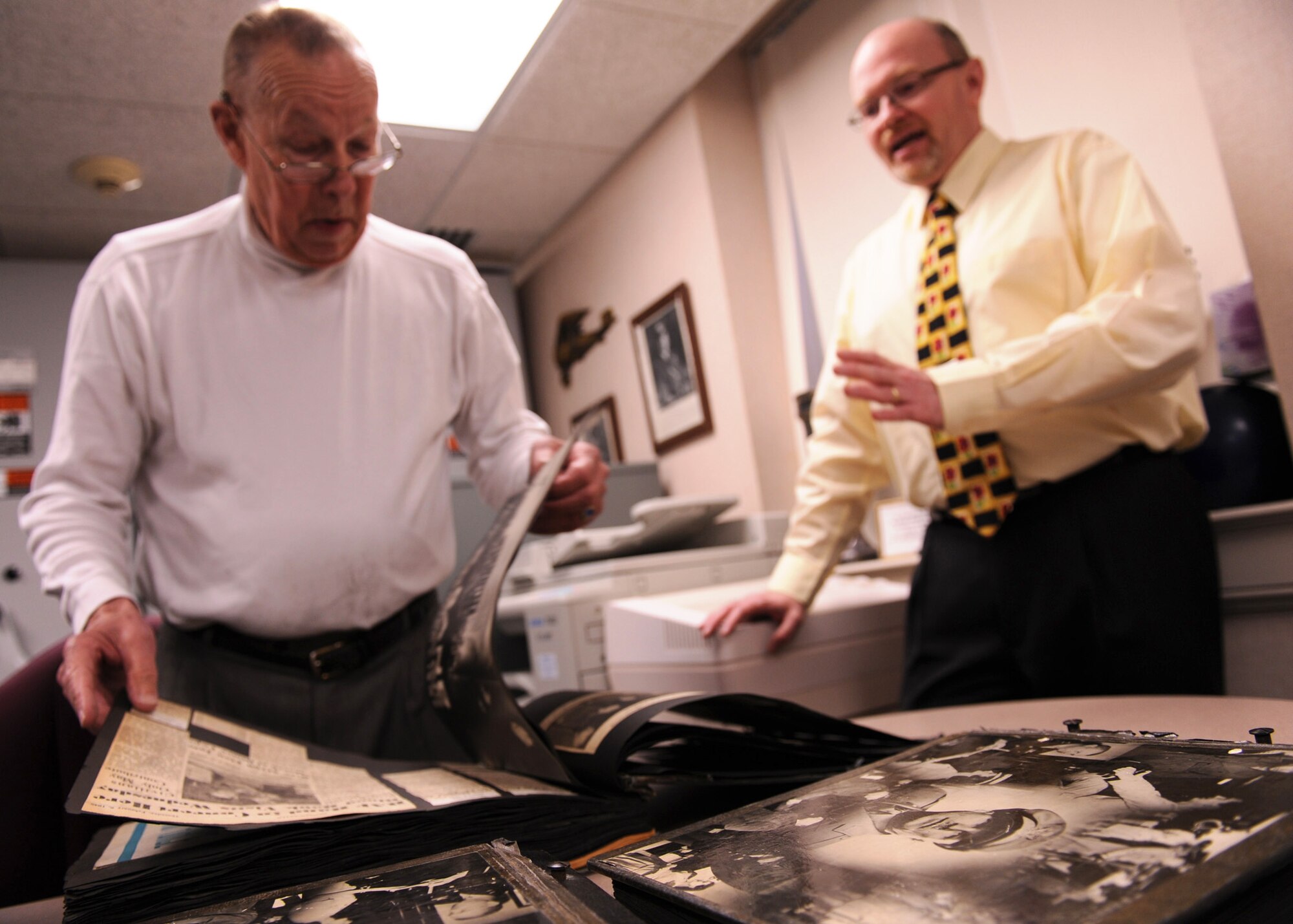 SCOTT AIR FORCE BASE, Ill. --Retired Army Maj. Gen. Neal Creighton flips through news clippings and photographs pertaining to Scott during the 1940s before donating the books to Frederick Smith (right), 375th Airlift Wing historian. The books were prepared by the staff of his father, Army Air Corps Col. Neal Creighton, who commanded Scott Field from 1945-1946.(U.S. Air Force photo/Staff Sgt. Paul Villanueva II)