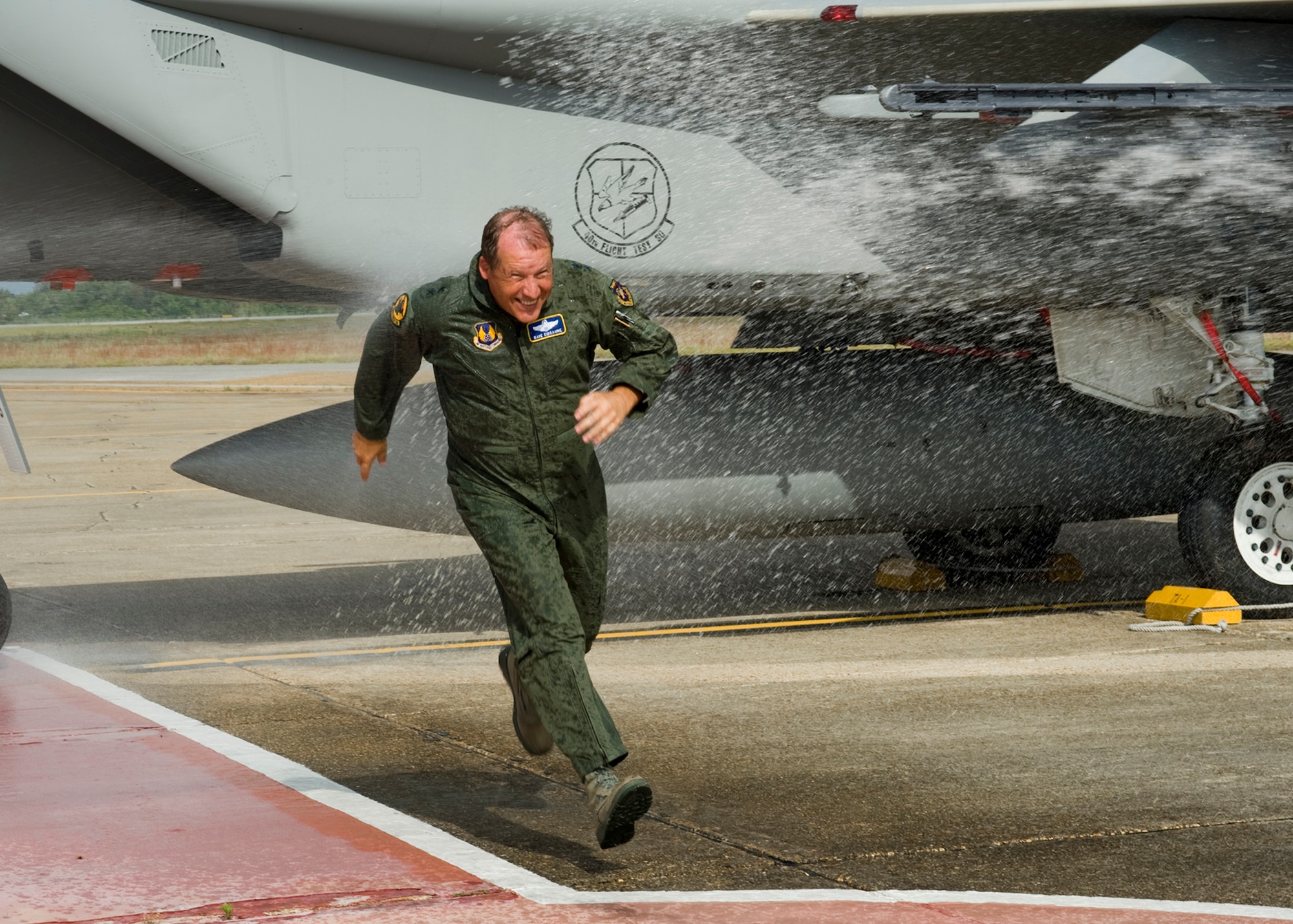 Maj. Gen. David Eidsaune, Air Armament Center commander, tries to dodge the traditional hosing after his final flight as commander, April 27 at Eglin Air Force Base.  Staff members, family and well-wishers particpated in drenching the commander.  General Eidsaune reliquishes command of the AAC May 1, for an assignment at Air Force Materiel Command headquarters.  Courtesy photo.
