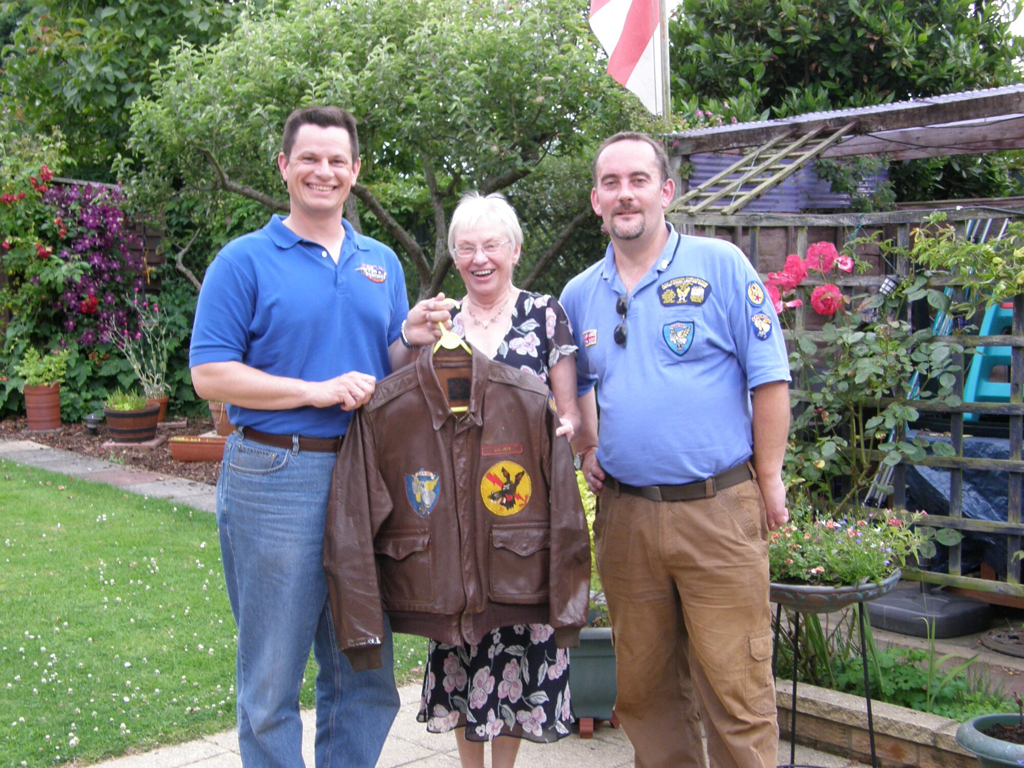 ELMENDORF AIR FORCE BASE, Alaska? ELMENDORF AIR FORCE BASE, Alaska--From left to right is Lt. Col. Robert Renner, a member of the 19th fighter squadron retrieves a WWII fighter jacket from Dianne Mills and Ian White,305th Bomb Group Memorial organizer. The jacket was originally belonged to a member of the 19th fighter squadron, Major Jay Moore?s grandfather.