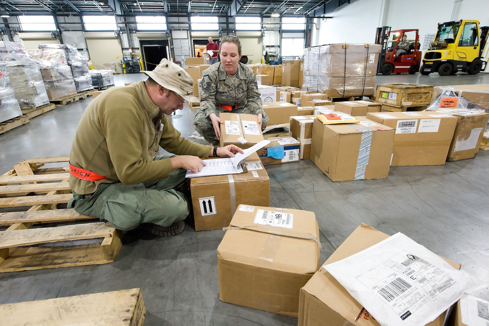 (From left) Timothy Goodrich and Master Sgt. Renee Munshower, 436th Aerial Port Squadron, check packages that just arrived at the Super Port April 2. More than 17,000 pounds of cargo moved through the Super Port during the month of March. (U.S. Air Force photo/Jason Minto)