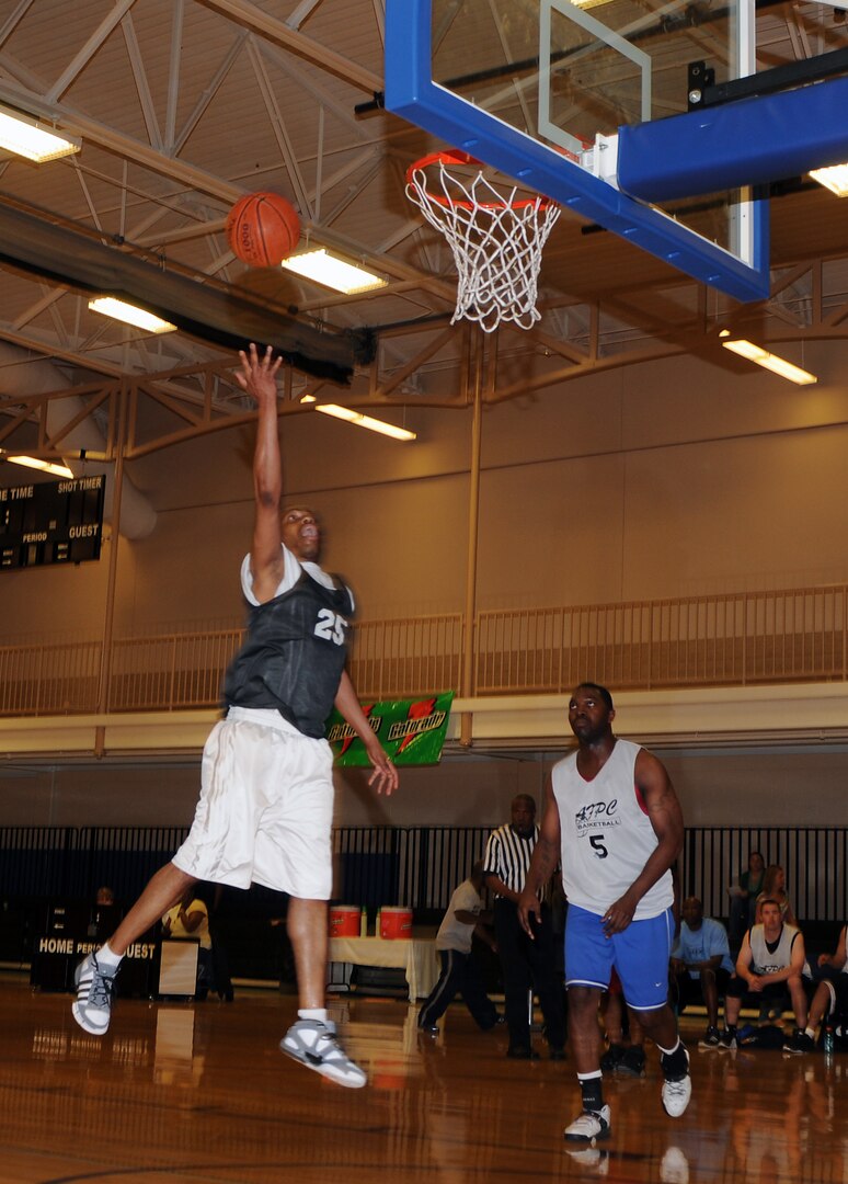 Greg Walker, Medical Group #1 intramural basketball team, goes for a layup while William Jones, Air Force Personnel Center team member, heads in for the defense April 24 at the Rambler Fitness Center. AFPC edged MDG #1, 47-42, to earn this year's championship title. (U.S. Air Force photo by Steve White)