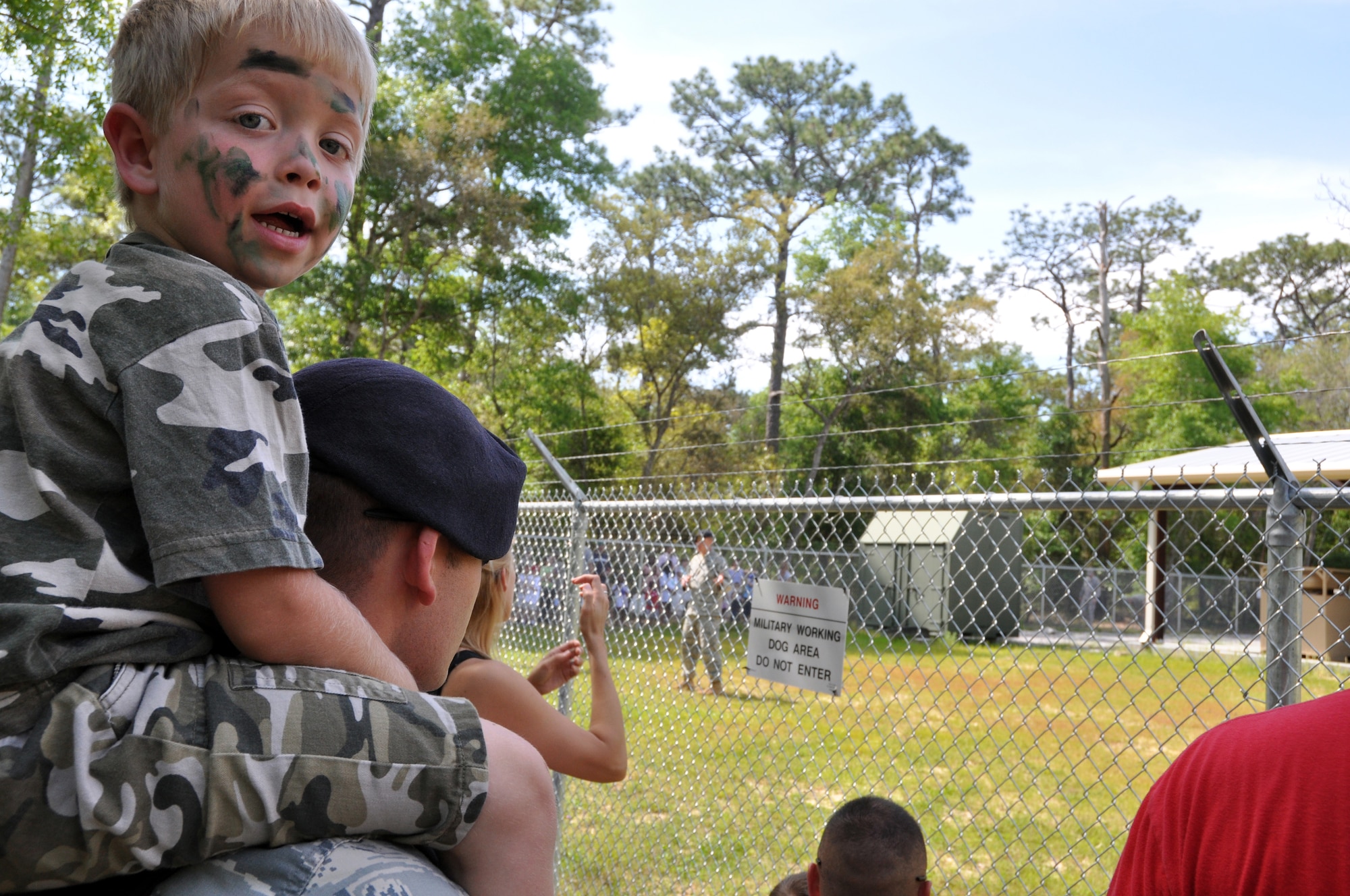 EGLIN AIR FORCE BASE, Fla. -- Senior Airman George Clifton, 96th Security Forces Squadron, and his son Ashot, 4, witness a Military Working Dog demonstration at the dog compound. 163 children of Team Eglin personnel got the opportunity to experience the deployment process April 25, during Operation Hero. The event helped children to understand what their parents must endure during deployment and alleviated the anxiety that may accompany a loved one's departure. (U.S. Air Force photo/ Airman Anthony Jennings)