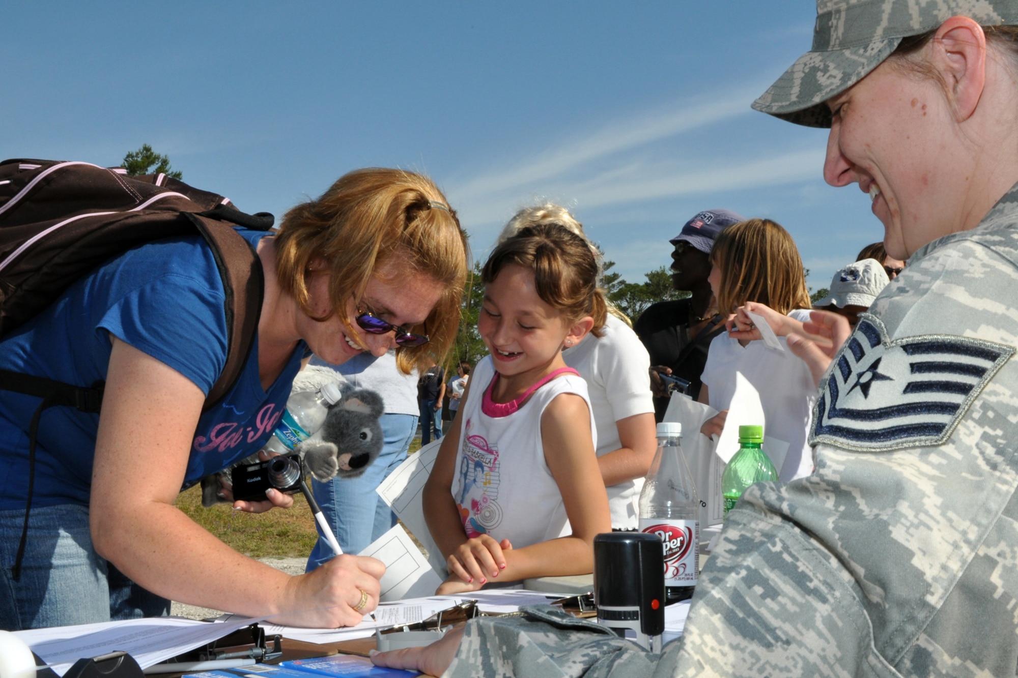 EGLIN AIR FORCE BASE, Fla. -- Kacie Eveland, 8, and her mother Michele sign power-of-attorney papers before departing to Base Tango, a simulated base in the area of responsibility. 163 children of Team Eglin personnel got the opportunity to experience the deployment process April 25, during Operation Hero. The event helped children to understand what their parents must endure during deployment and alleviated the anxiety that may accompany a loved one's departure. (U.S. Air Force photo/ Airman Anthony Jennings)