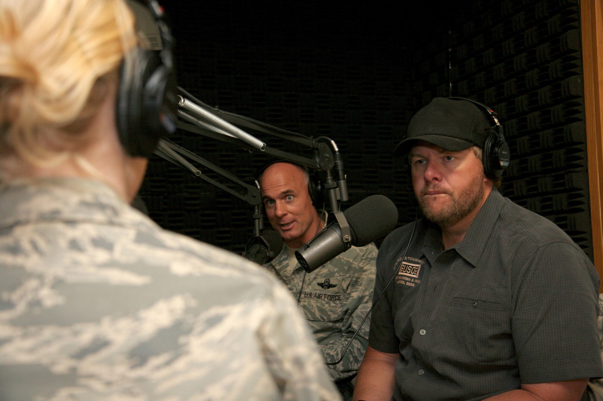Brig. Gen. Craig Franklin, 31st Fighter Wing commander, and country music superstar Toby Keith, are interviewed by Senior Airman Caitlin Jones on American Forces Network Aviano's ZFM 106 morning show at Aviano Air Base, Italy, April 29.  Mr. Keith just returned from Afghanistan where he was entertaining the troops on his USO sponsored "America's Toughest Tour 2009".  He stopped by Aviano before continuing the tour with a concert at Camp Darby, Italy, April 29 and U.S. Army Garrison Vicenza, Italy April 30.  (U.S. Air Force photo/Senior Master Sgt. Robert W. Valenca) 